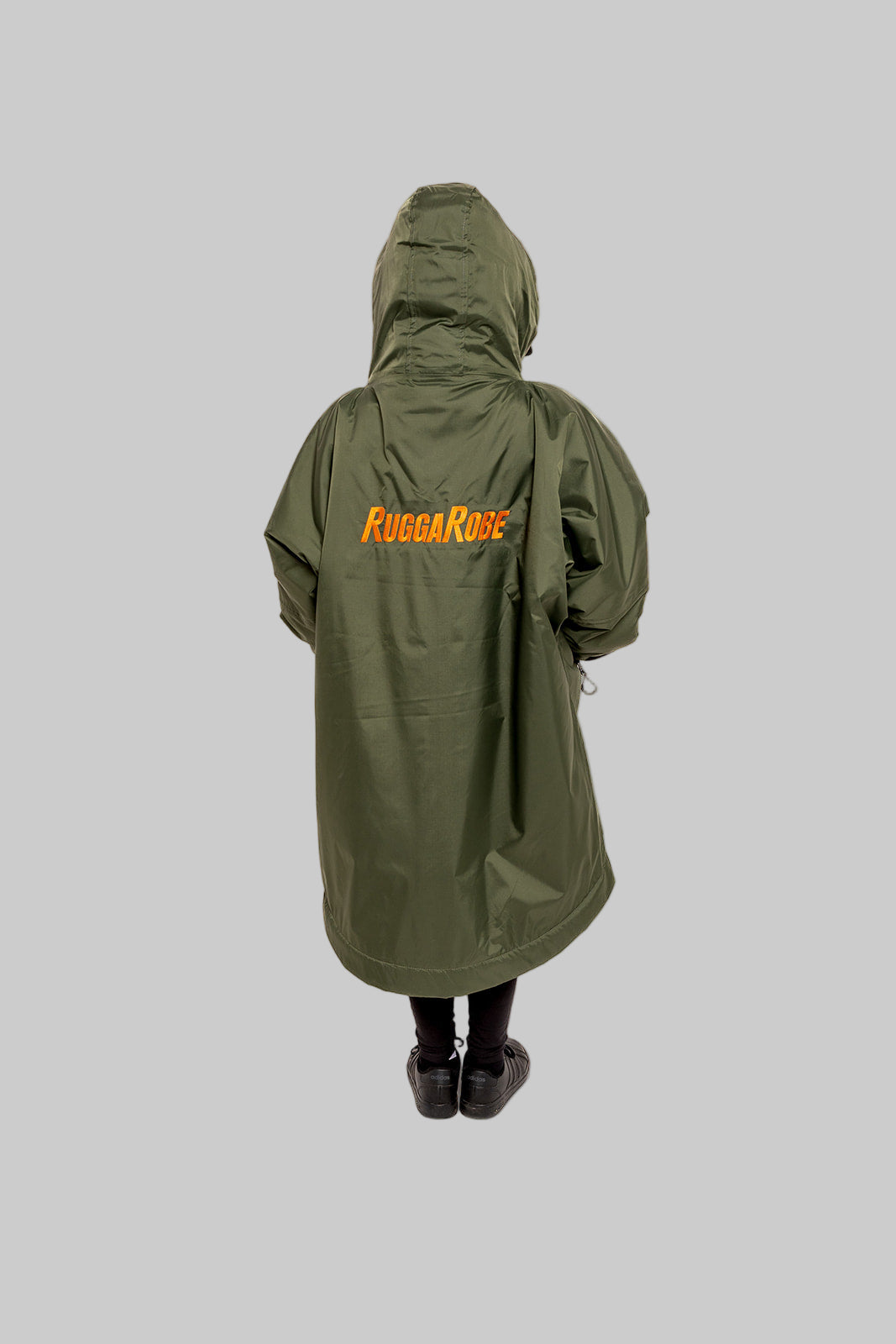 Model wearing RuggaRobe green change robe with orange fleece interior on grey background