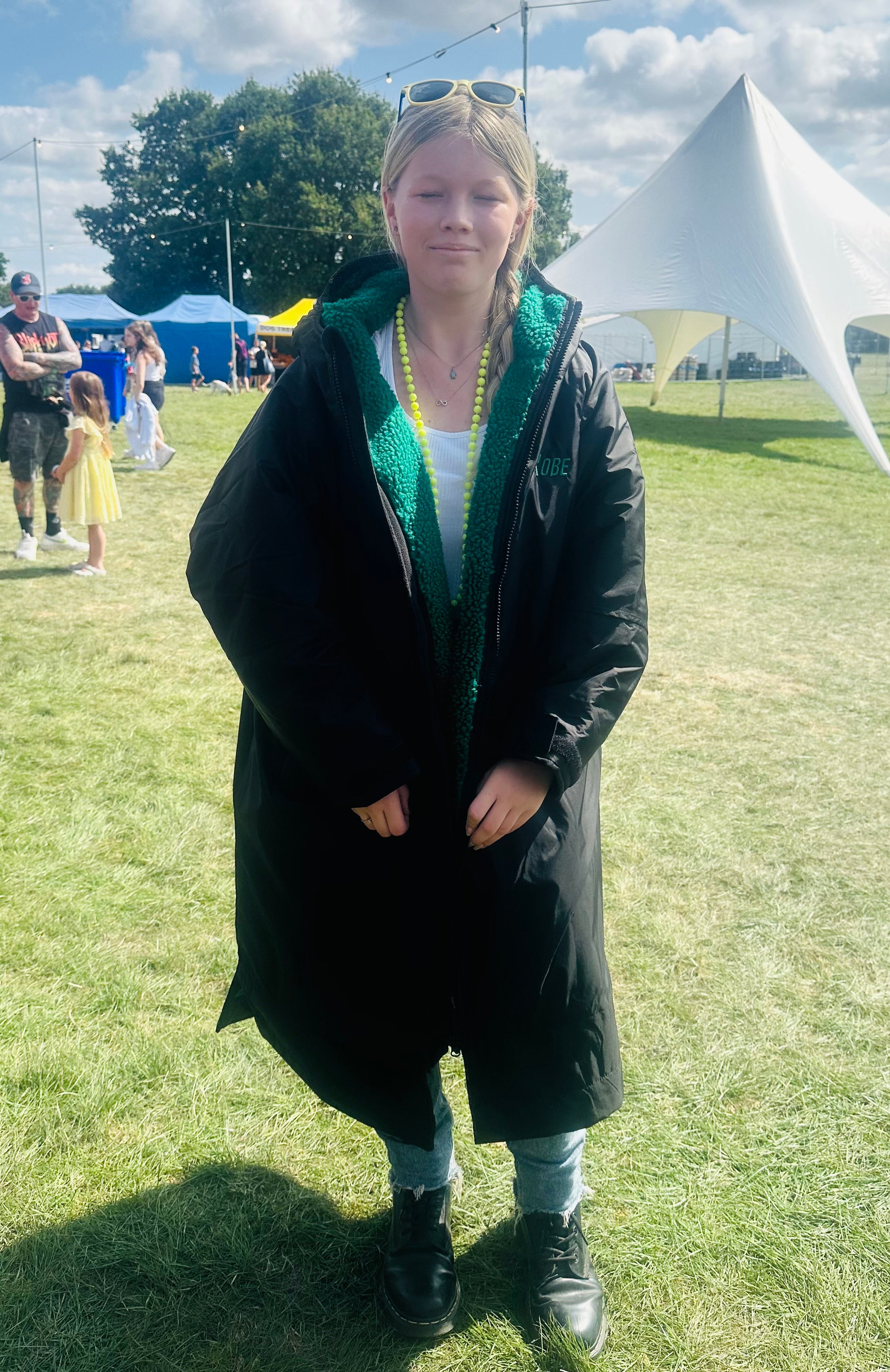 Person wearing a black jacket with 'RuggaRobe' text outdoors on a grassy field.