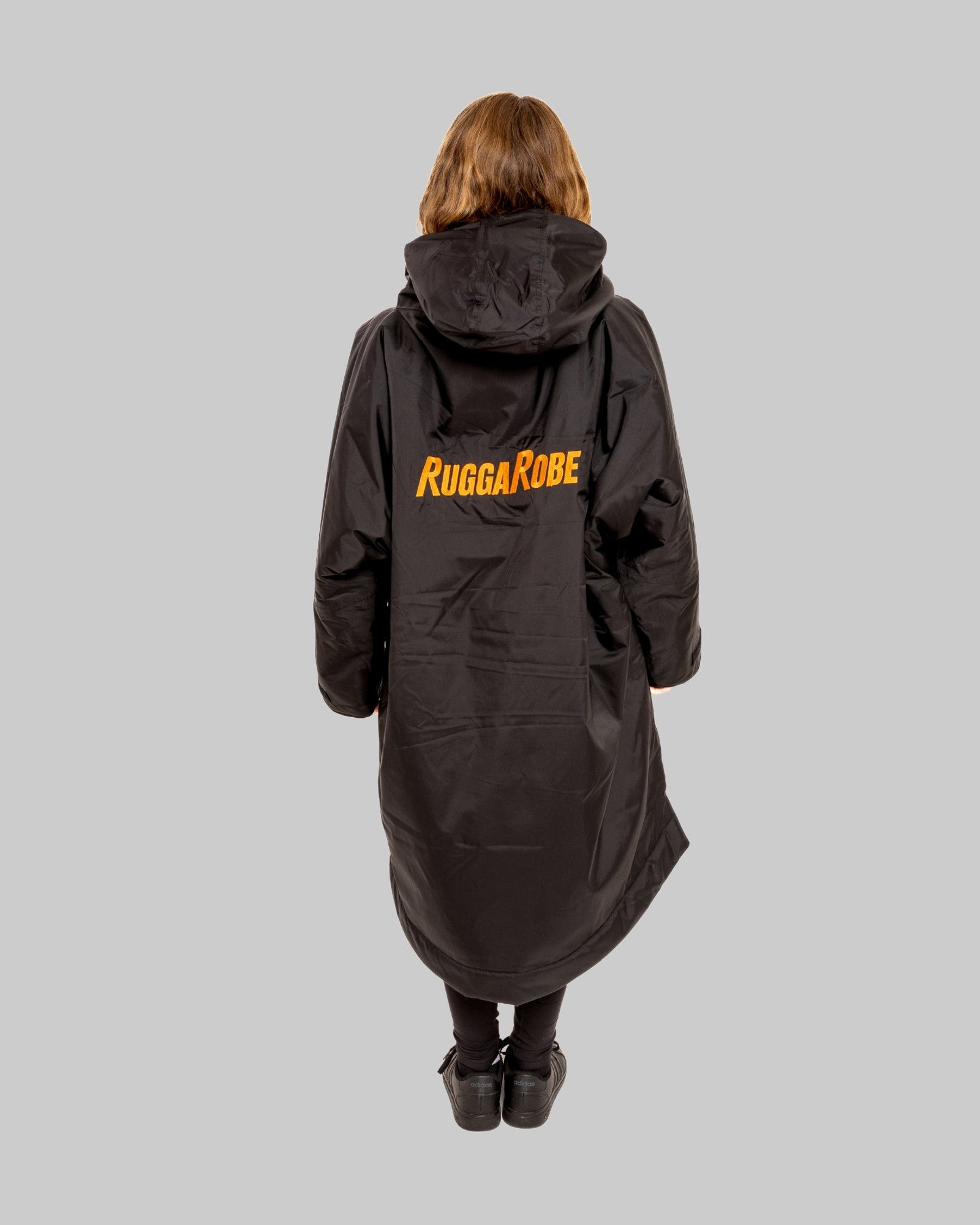 Model wearing RuggaRobe black change robe with black fleece interior on grey background