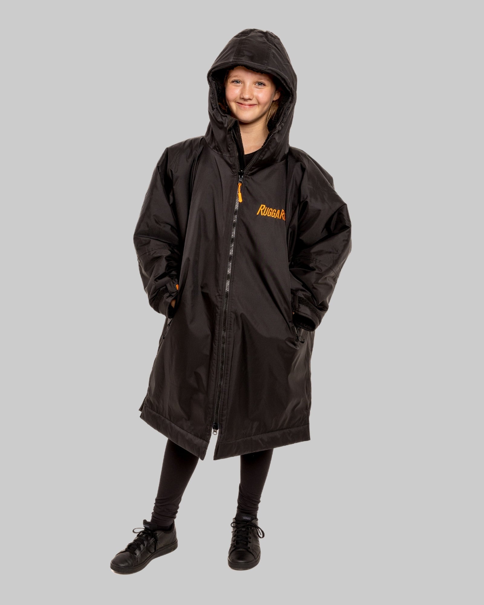 Child wearing RuggaRobe black change robe with black fleece interior on grey background
