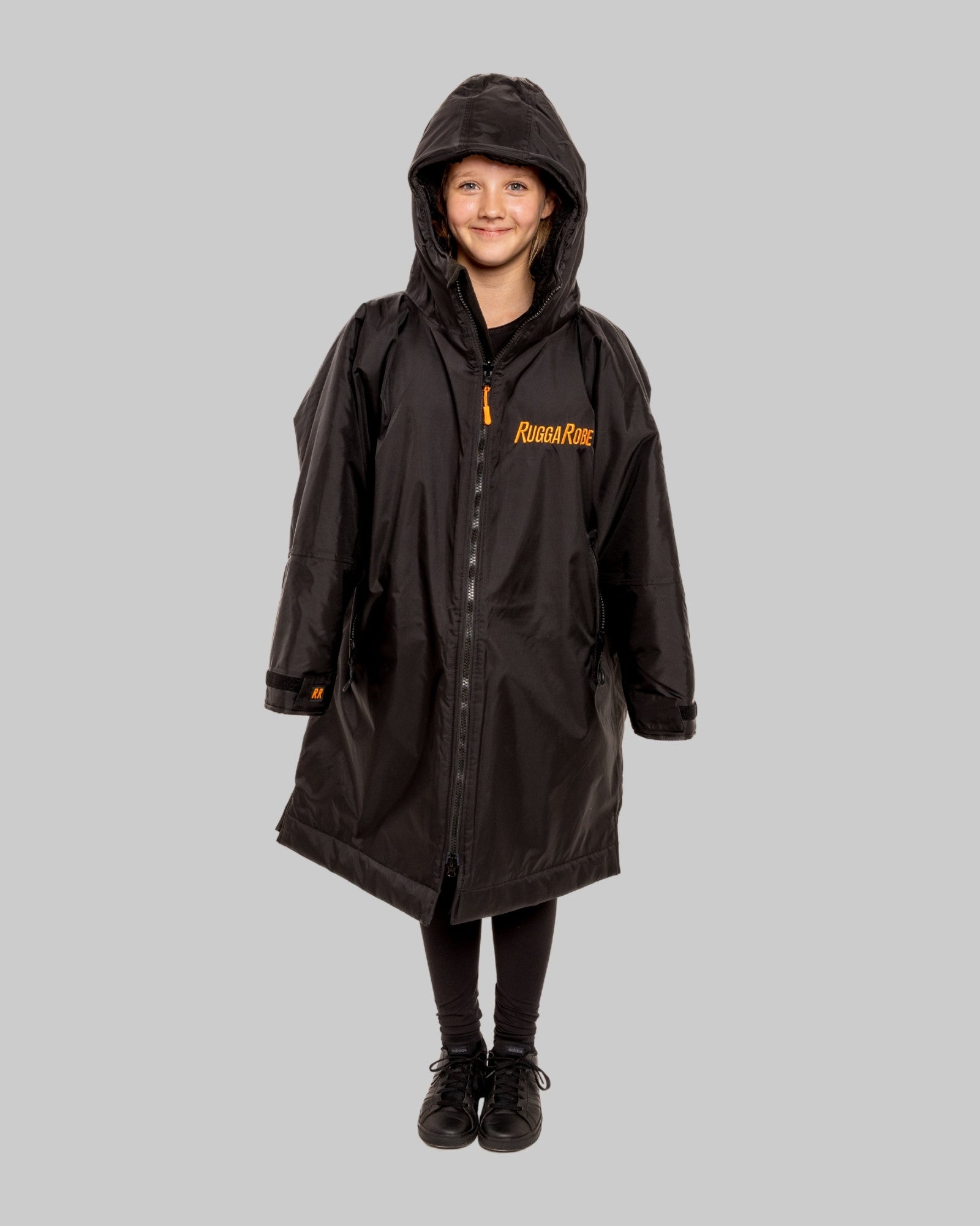 Child wearing RuggaRobe black change robe with black fleece interior on grey background