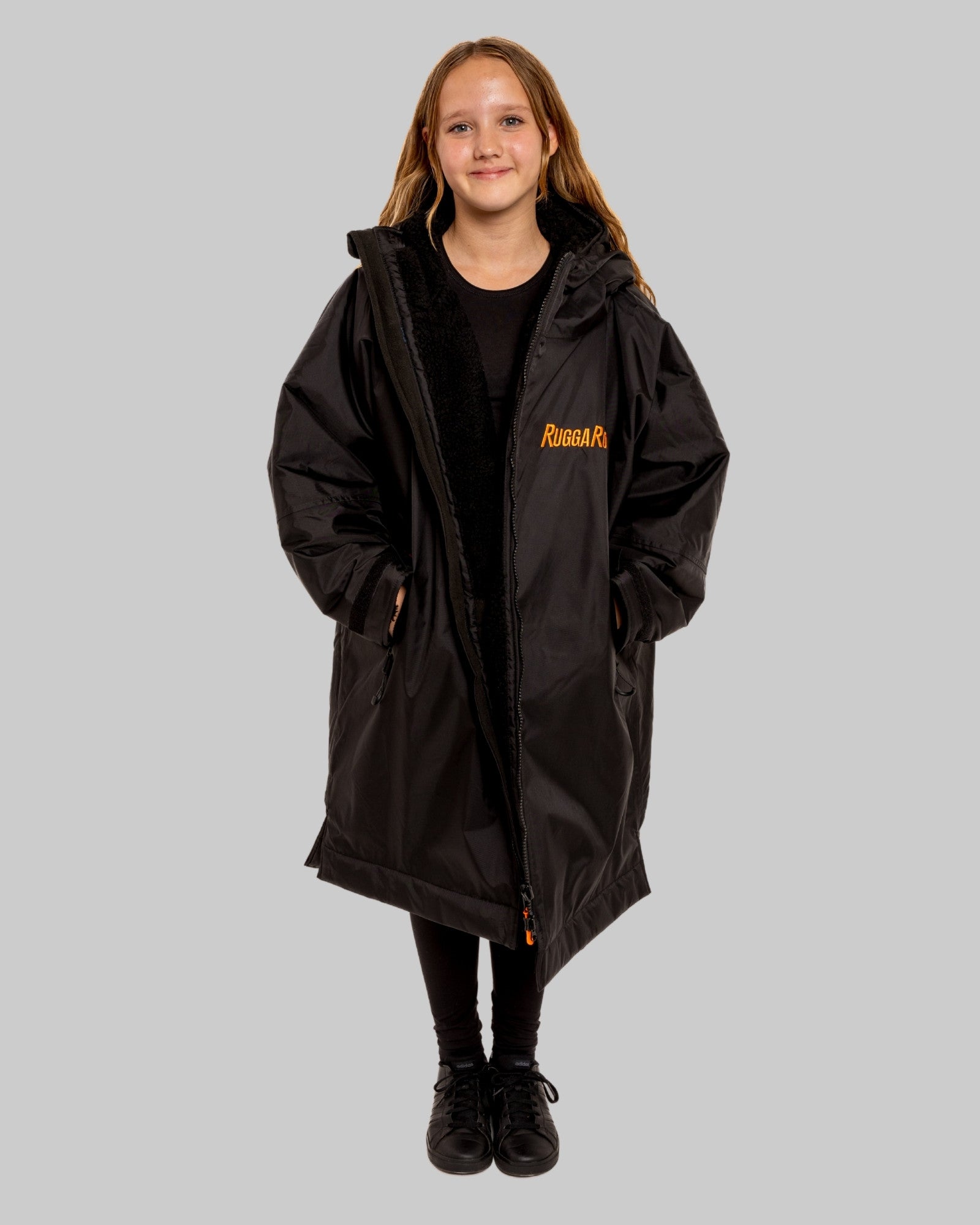 Model wearing RuggaRobe black change robe with black fleece interior on grey background