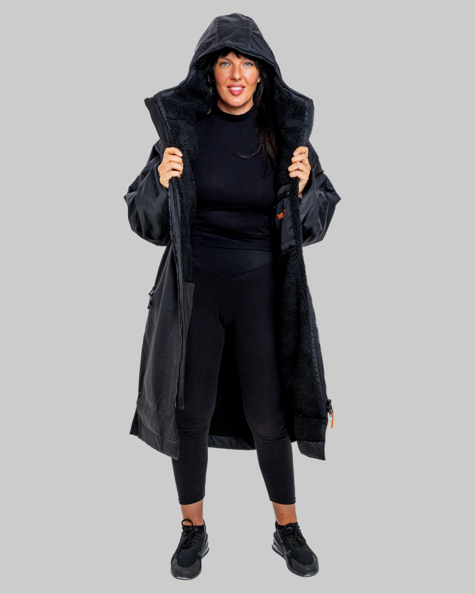 Person wearing a black ruggarobe with black interior on a grey background