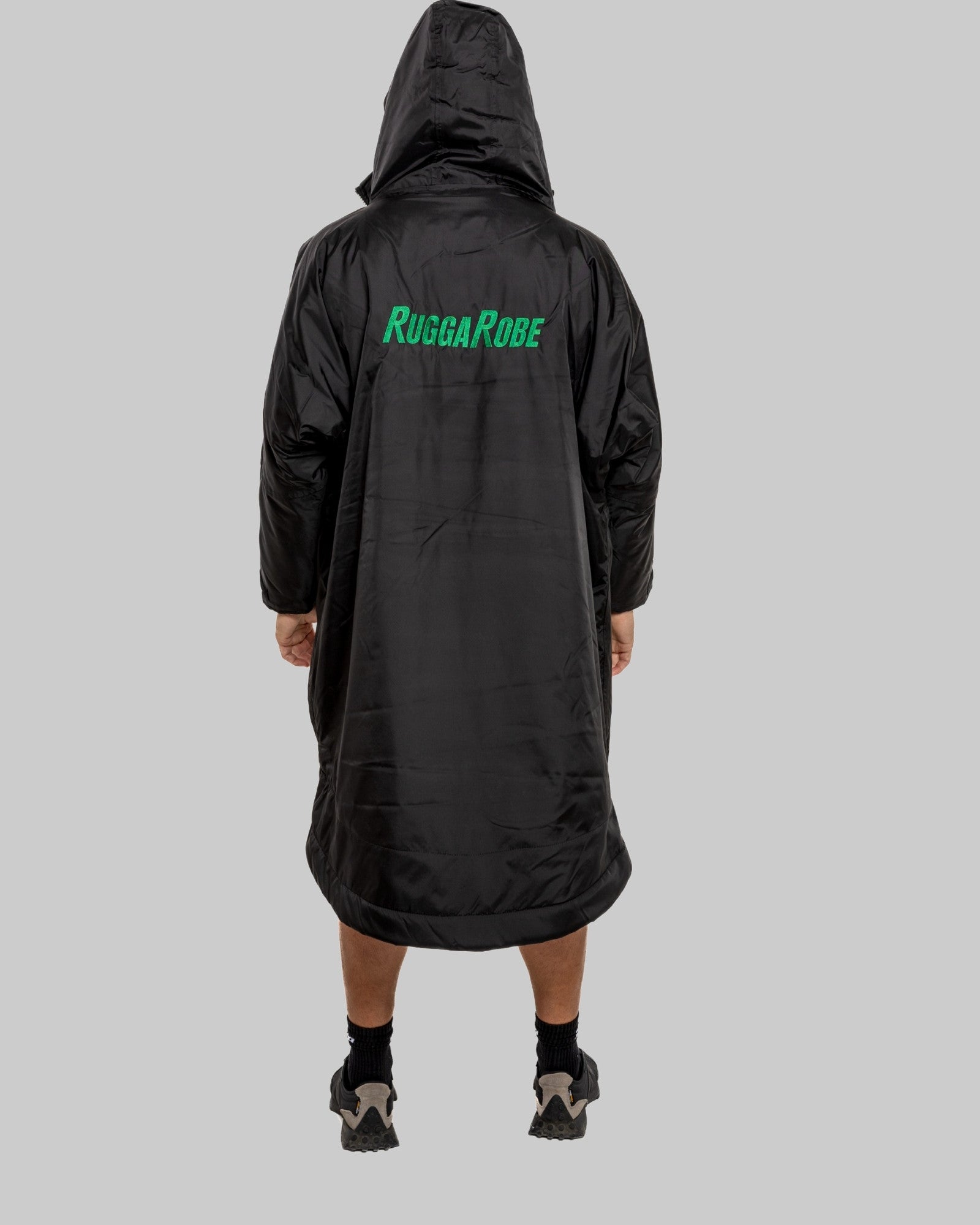 Person wearing a black RuggaRobe poncho on a gray background