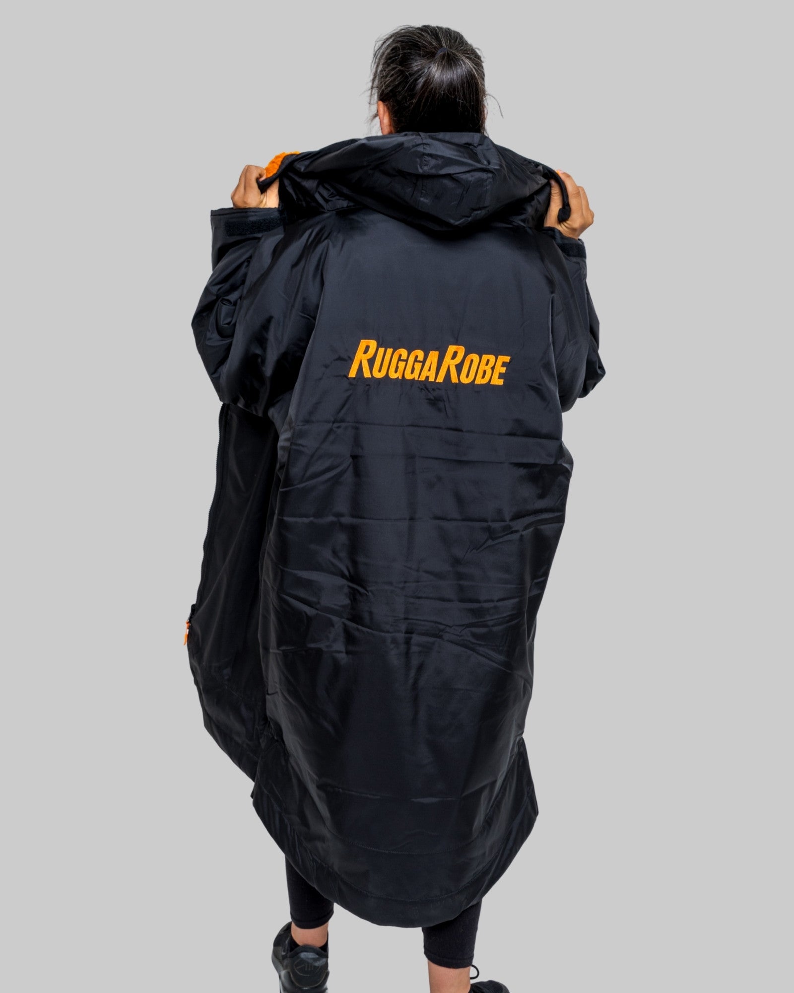 Person wearing a black 'RuggaRobe' robe on a gray background