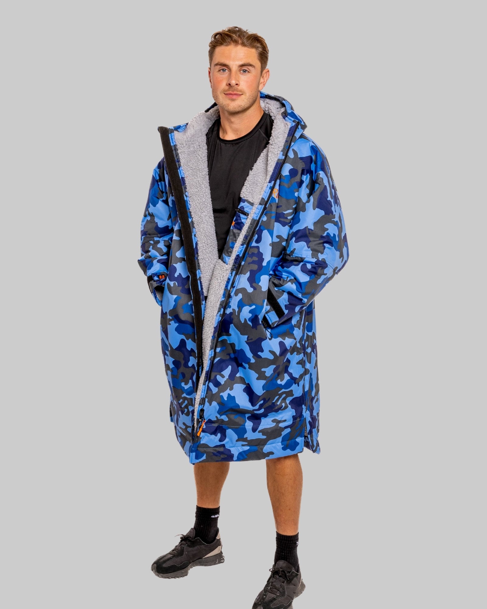 Man wearing a blue camouflage change robe on a grey background