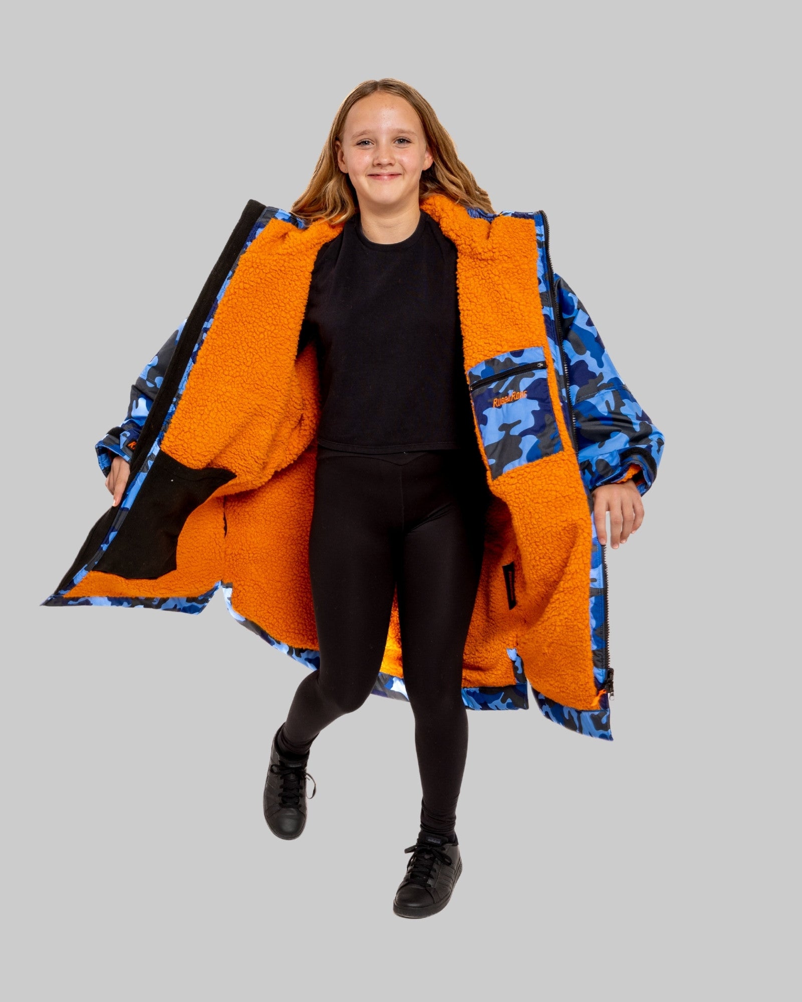 Model wearing RuggaRobe blue camo change robe with orange fleece interior on grey background