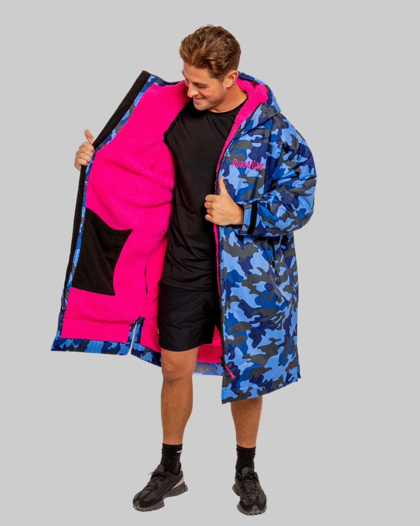Person wearing a blue camouflage ruggarobe with pink interior fleece on a gray background