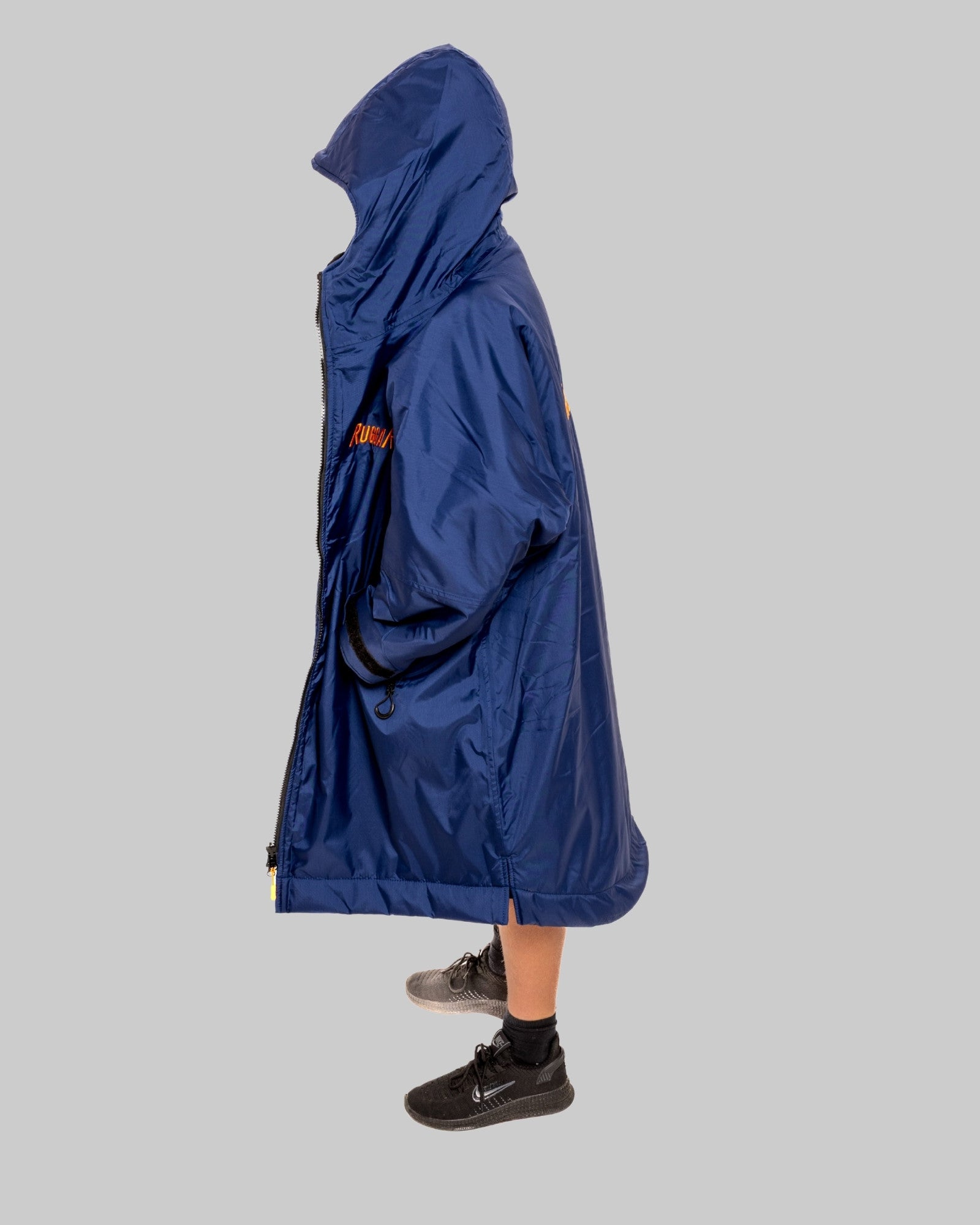 Child wearing a blue RugaRobe with grey fleece interior change robe on a grey background