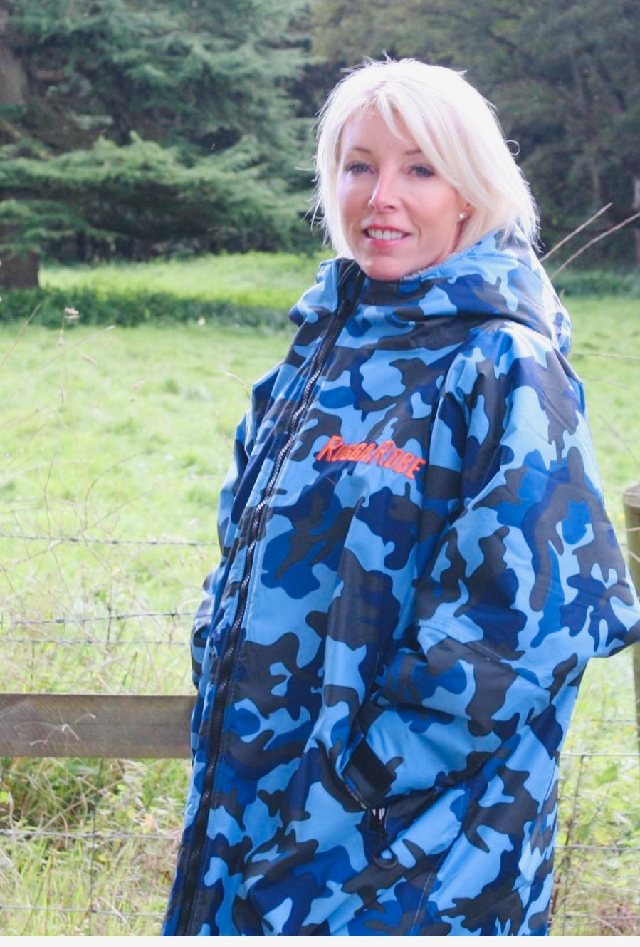 Person wearing a blue camouflage ruggarobe with a brand logo in an outdoor setting.