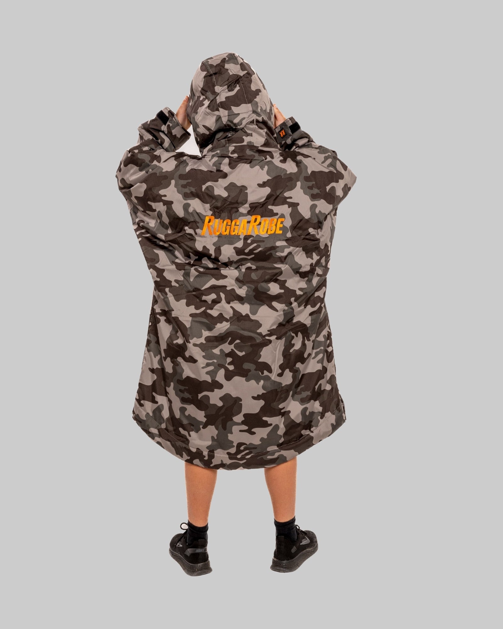 Model wearing RuggaRobe grey camo change robe with orange fleece interior on grey background