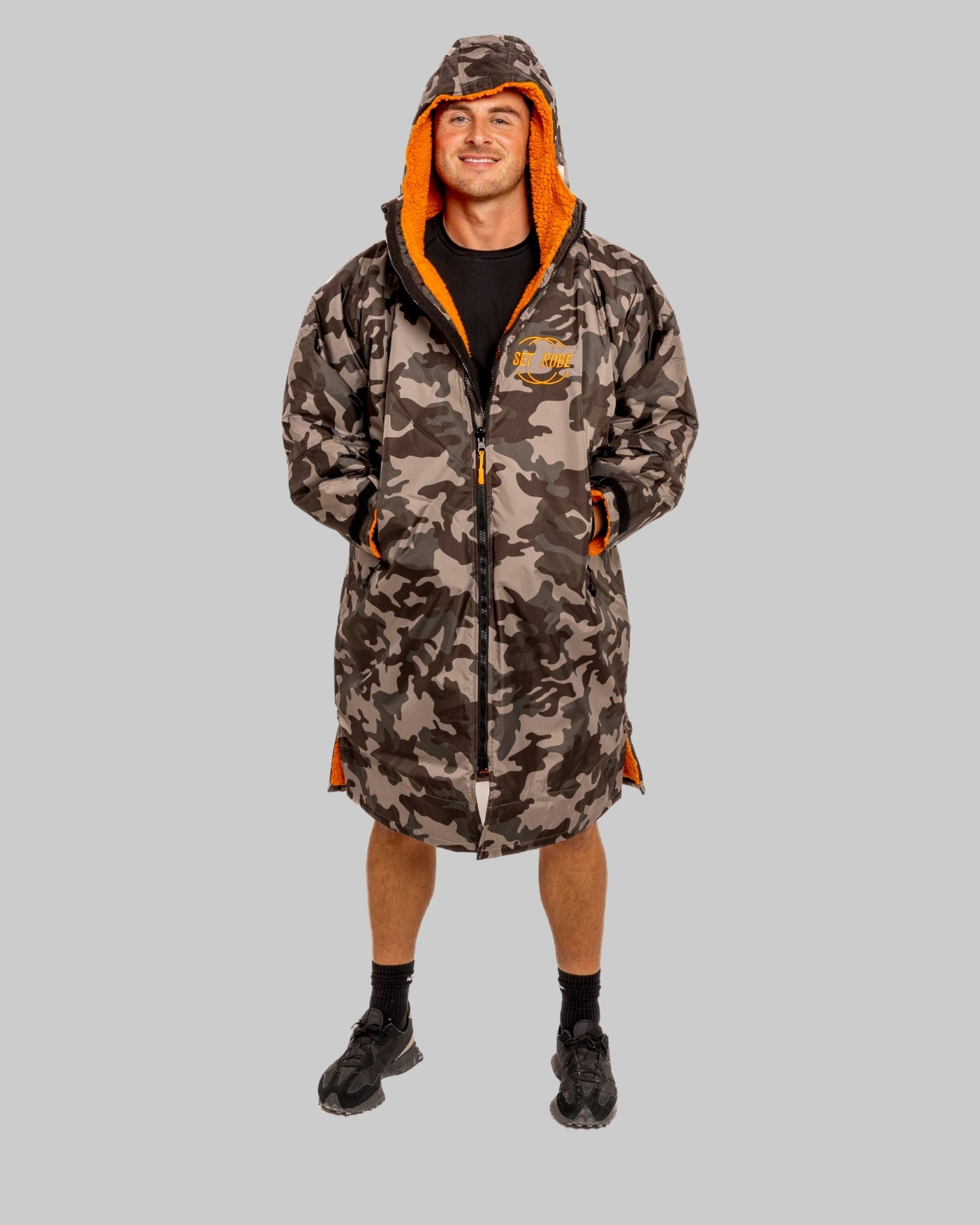 Model wearing RuggaRobe grey camo change robe with orange fleece interior on grey background