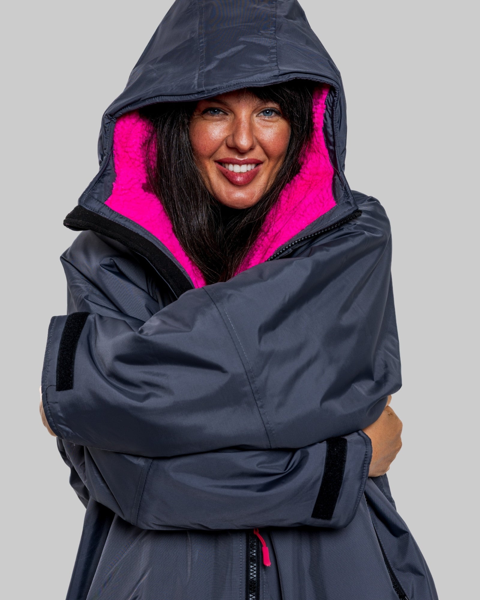 Model wearing RuggaRobe slate grey change robe with pink fleece interior on grey background