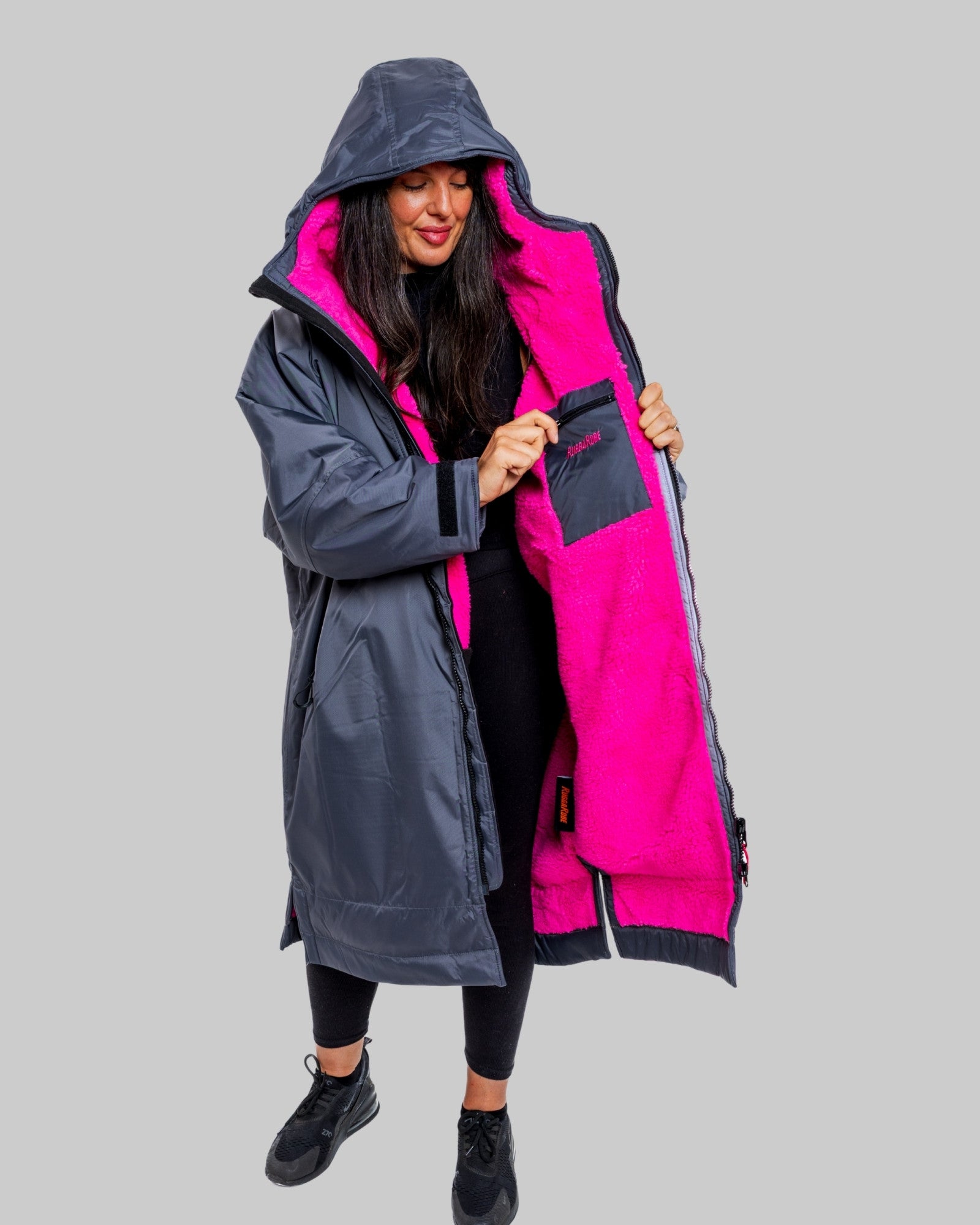 Model wearing RuggaRobe slate grey change robe with pink fleece interior on grey background