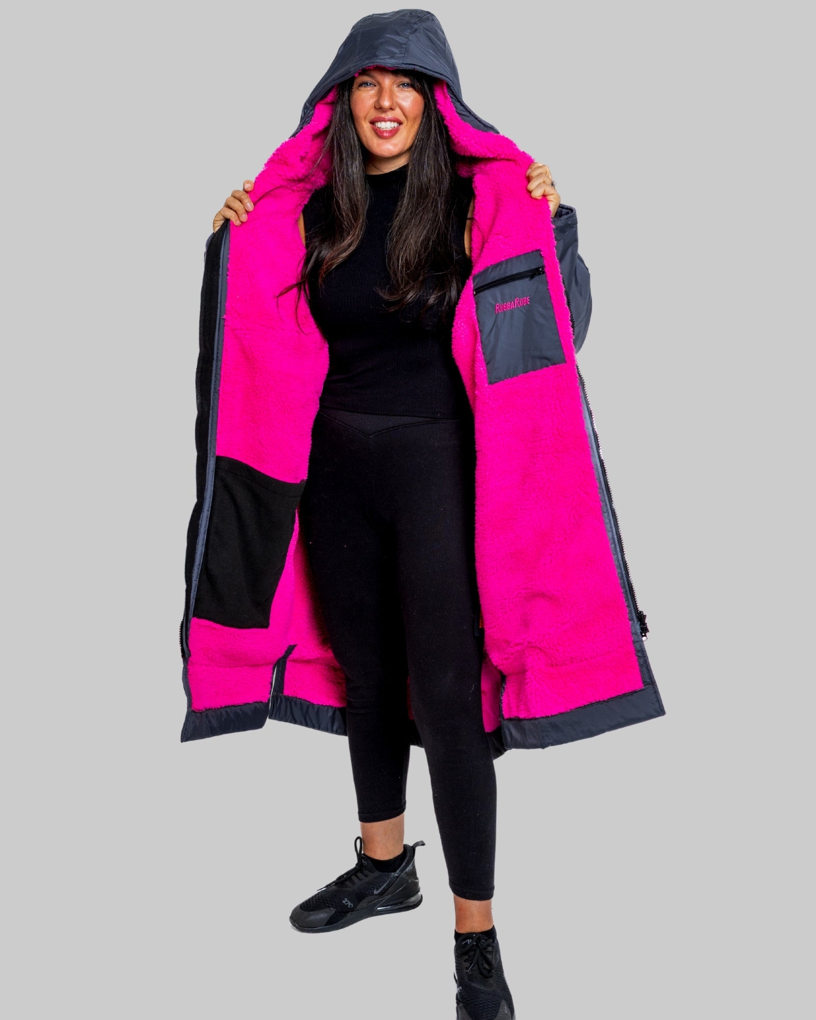 Model wearing RuggaRobe slate grey change robe with pink fleece interior on grey background