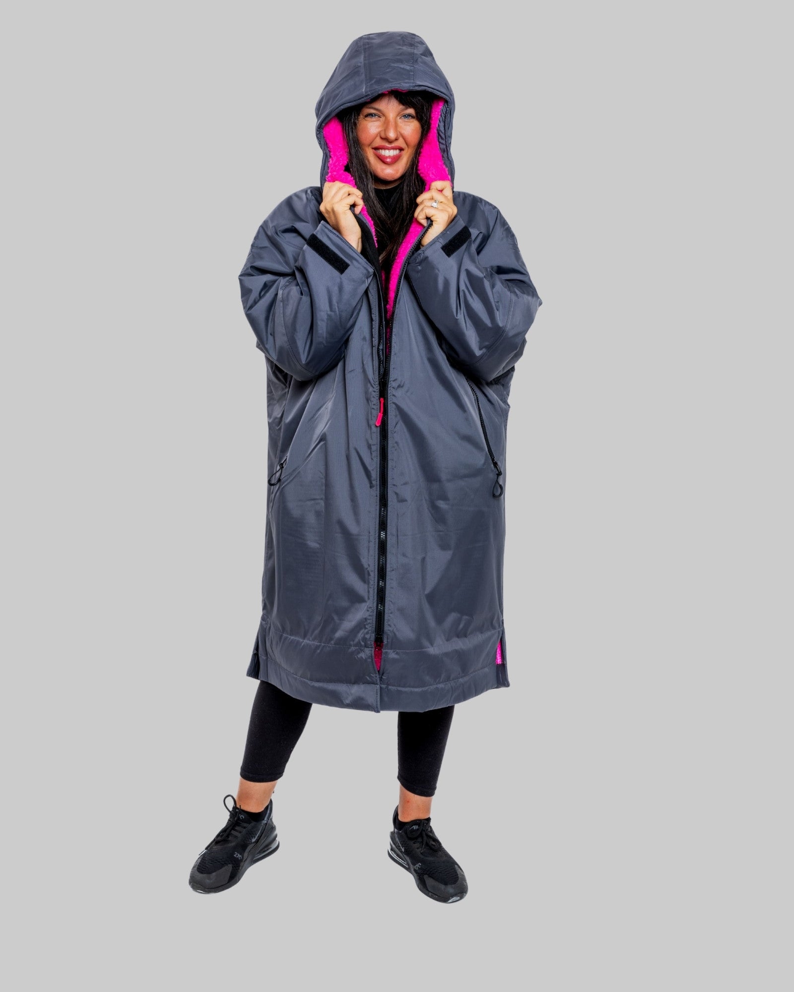 Model wearing RuggaRobe slate grey change robe with pink fleece interior on grey background