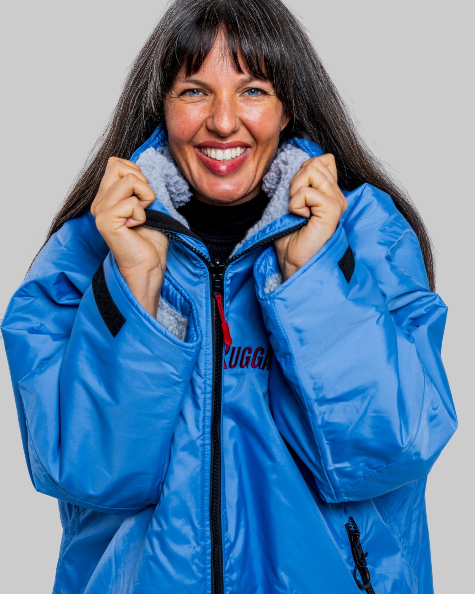 Woman wearing a pale blue with grey Ffeece ruggarobe on a gray background