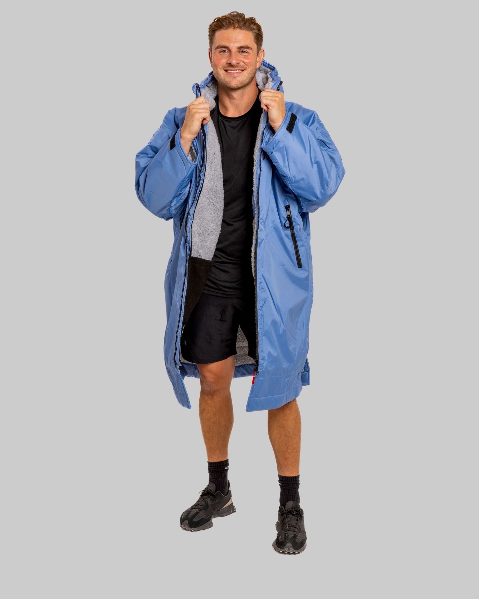 Man wearing a blue jacket on a gray background