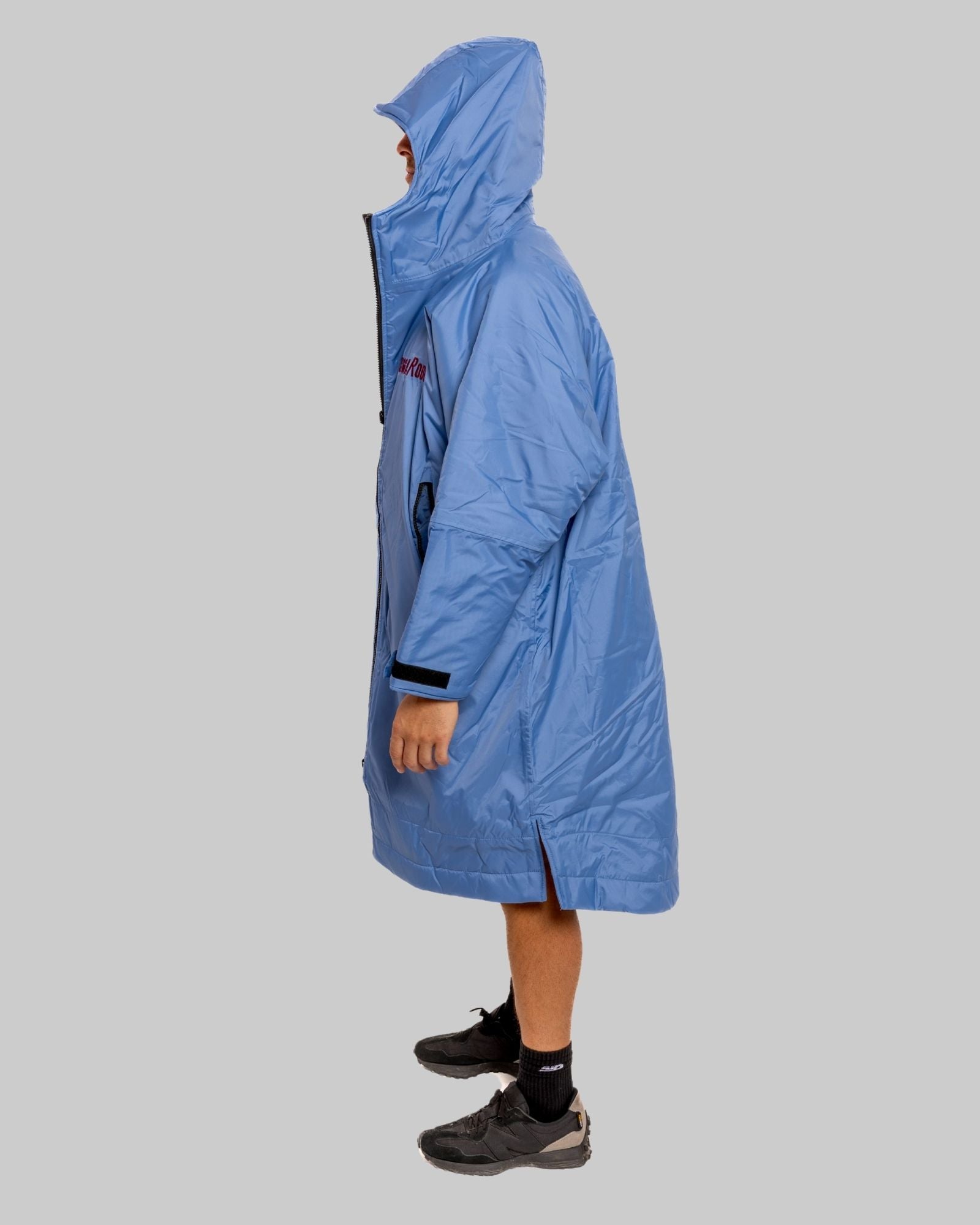 Person wearing a blue raincoat on a gray background