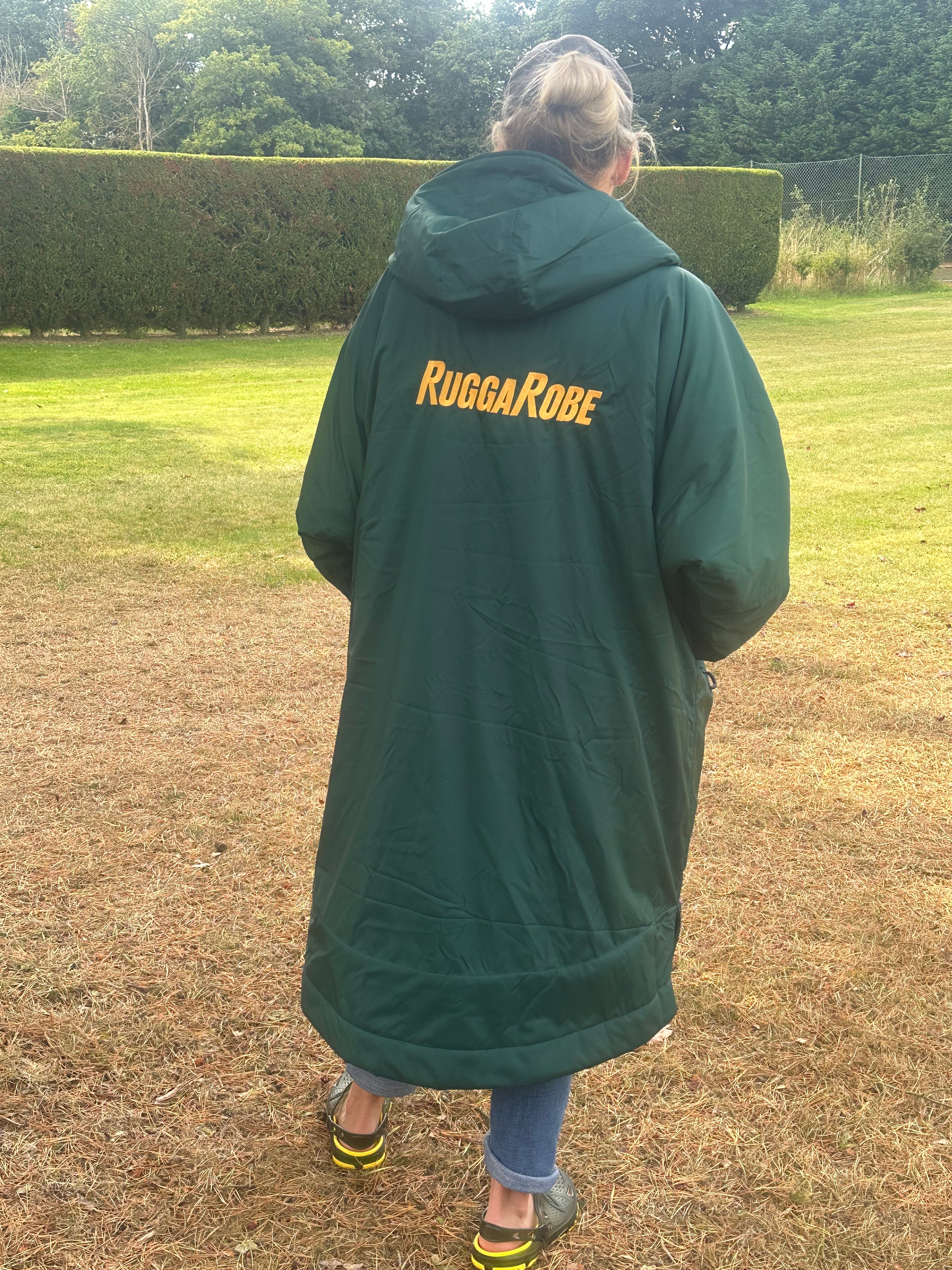 Person wearing a green with gold fleece change robe eith ruggarobe branding in a field