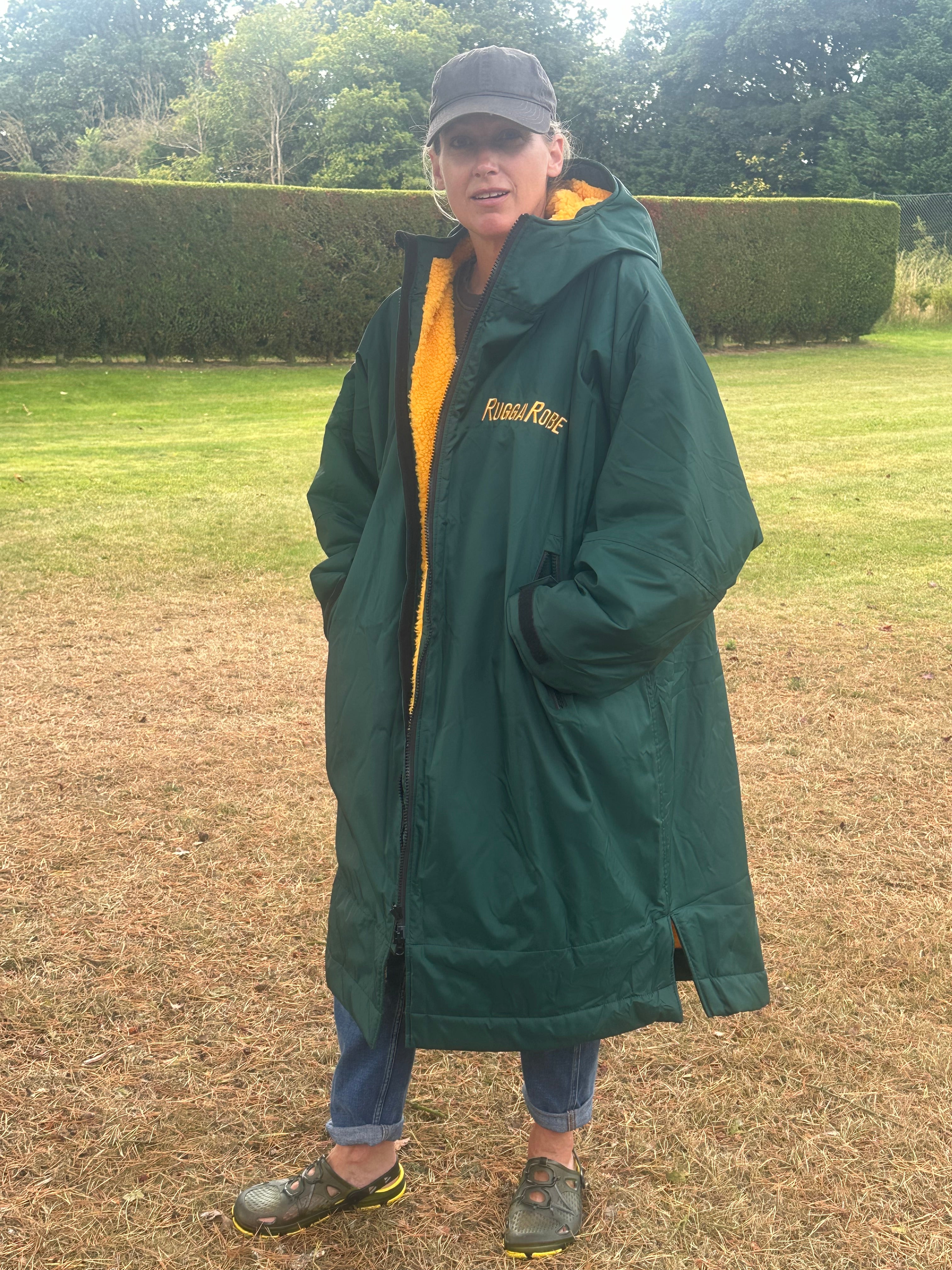 Person wearing a green with gold fleece change robe eith ruggarobe branding in a field