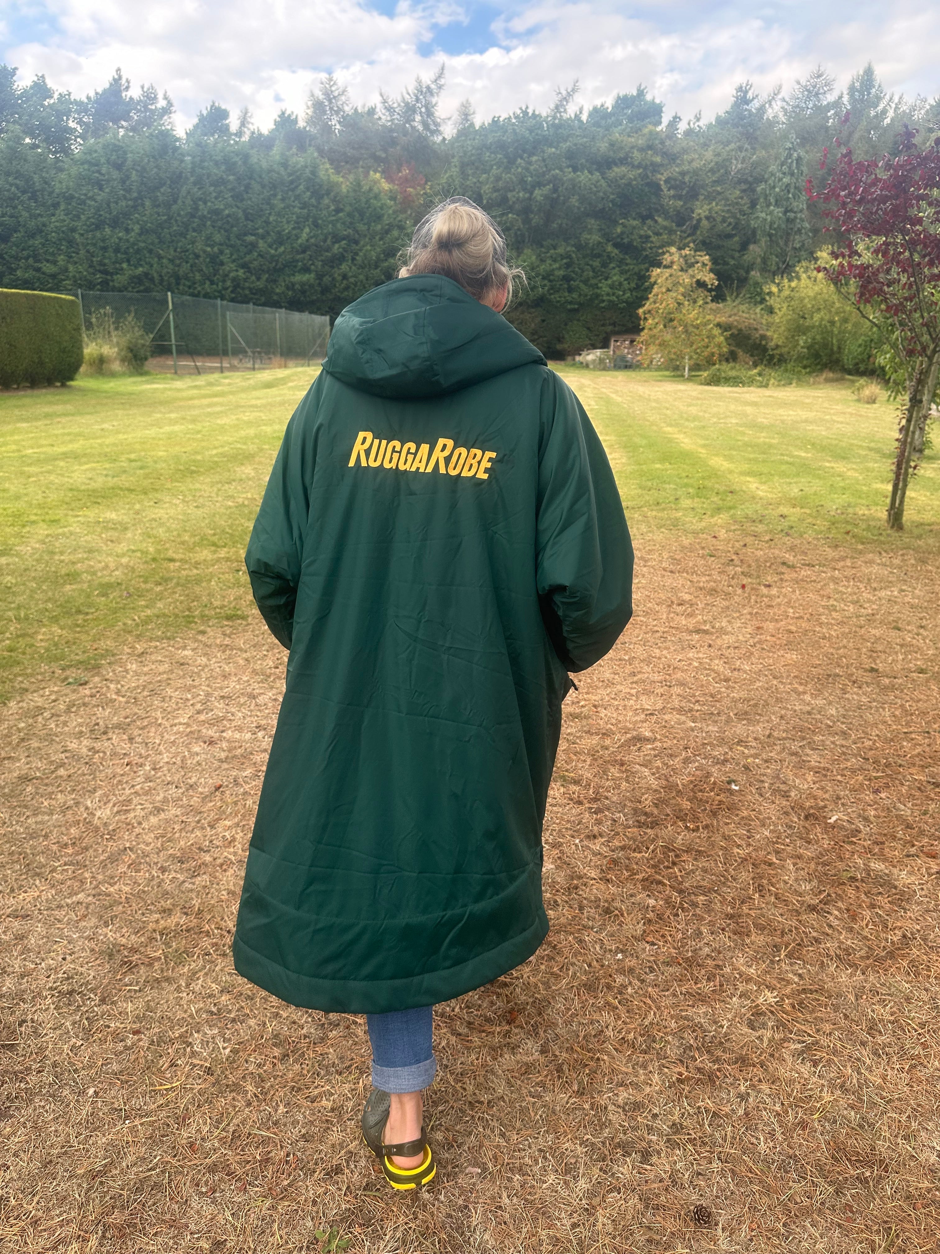 Person wearing a green with gold fleece change robe eith ruggarobe branding in a field