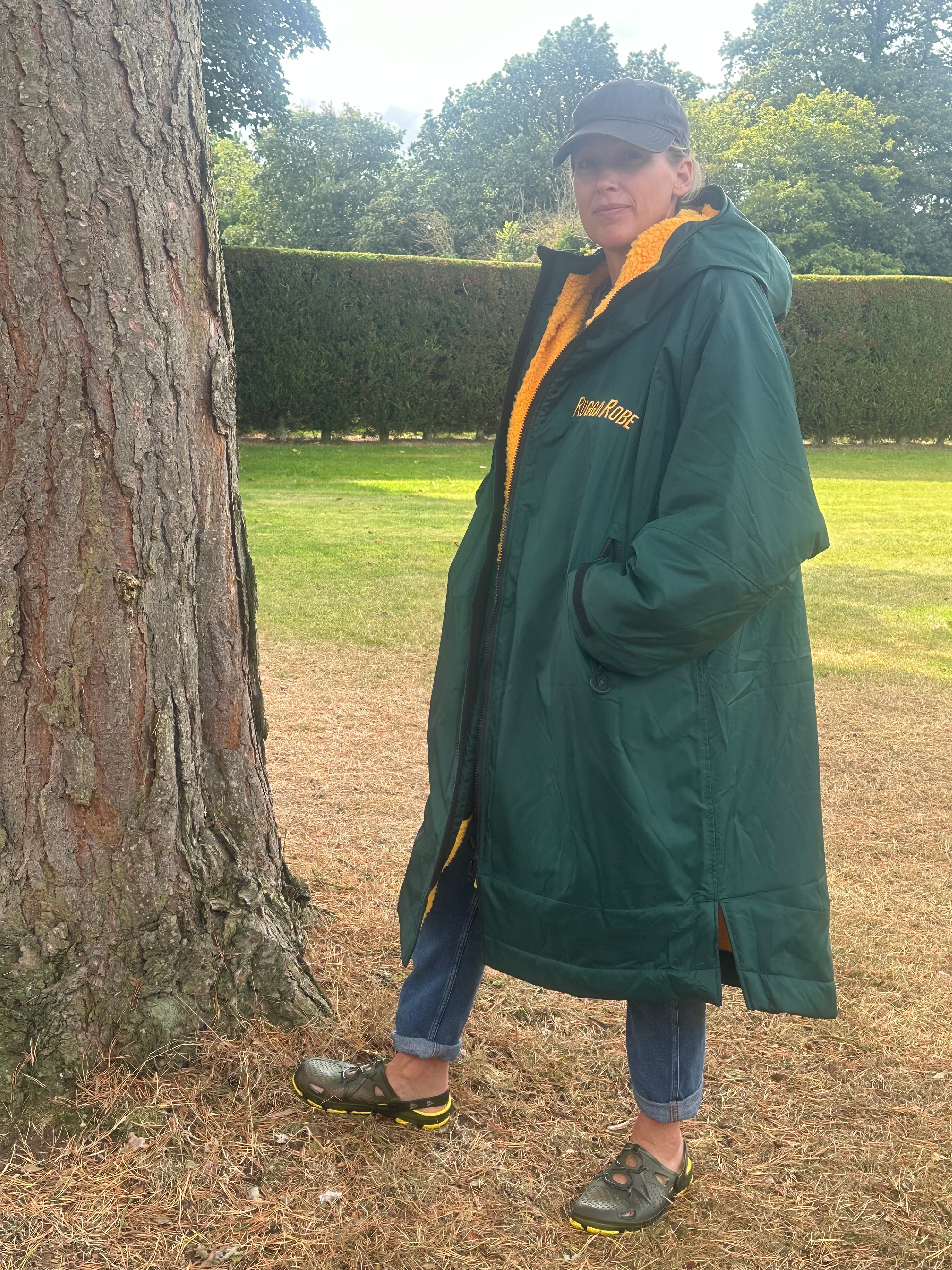 Person wearing a green with gold fleece change robe eith ruggarobe branding in a field