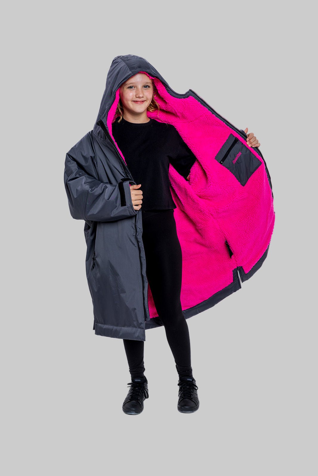 Model wearing RuggaRobe slate grey change robe with pink fleece interior on grey background