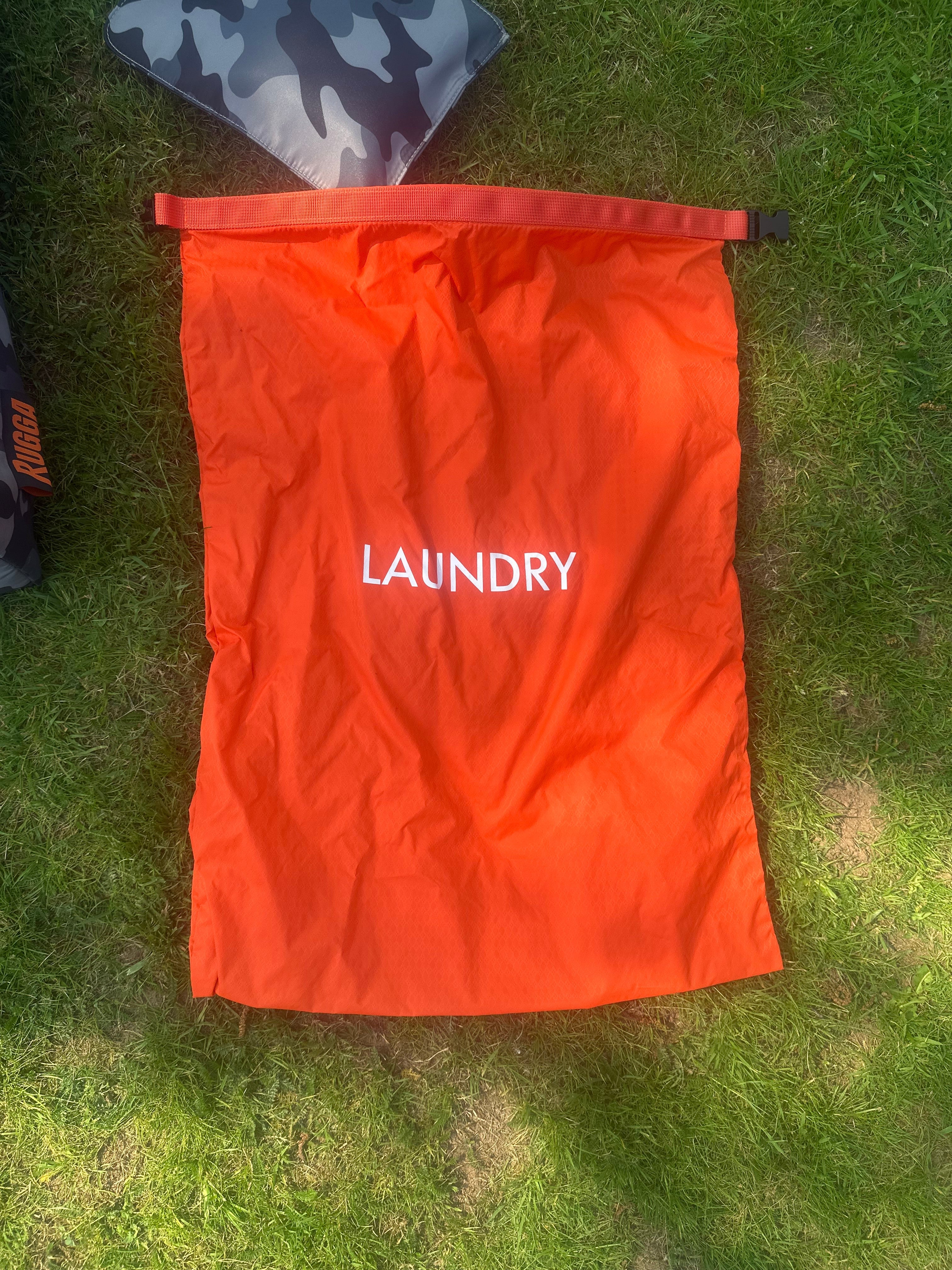 RuggaRobe Orange laundry bag with 'LAUNDRY' text on grass