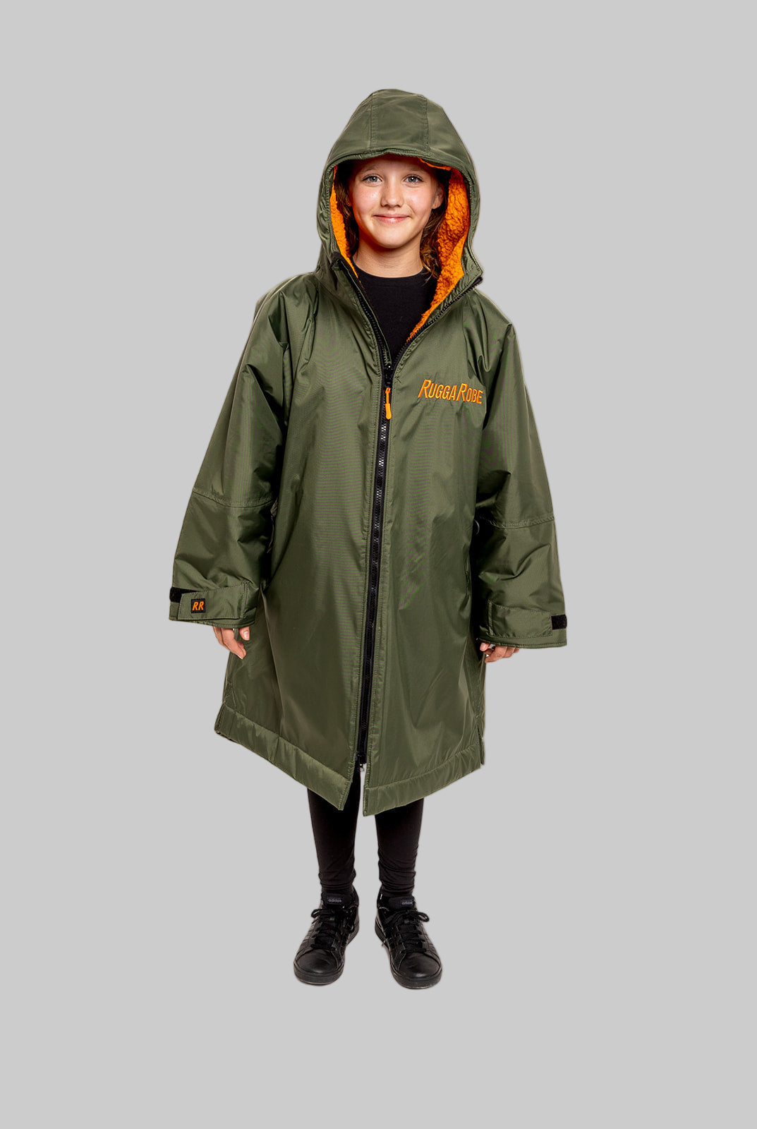 Model wearing RuggaRobe green change robe with orange fleece interior on grey background