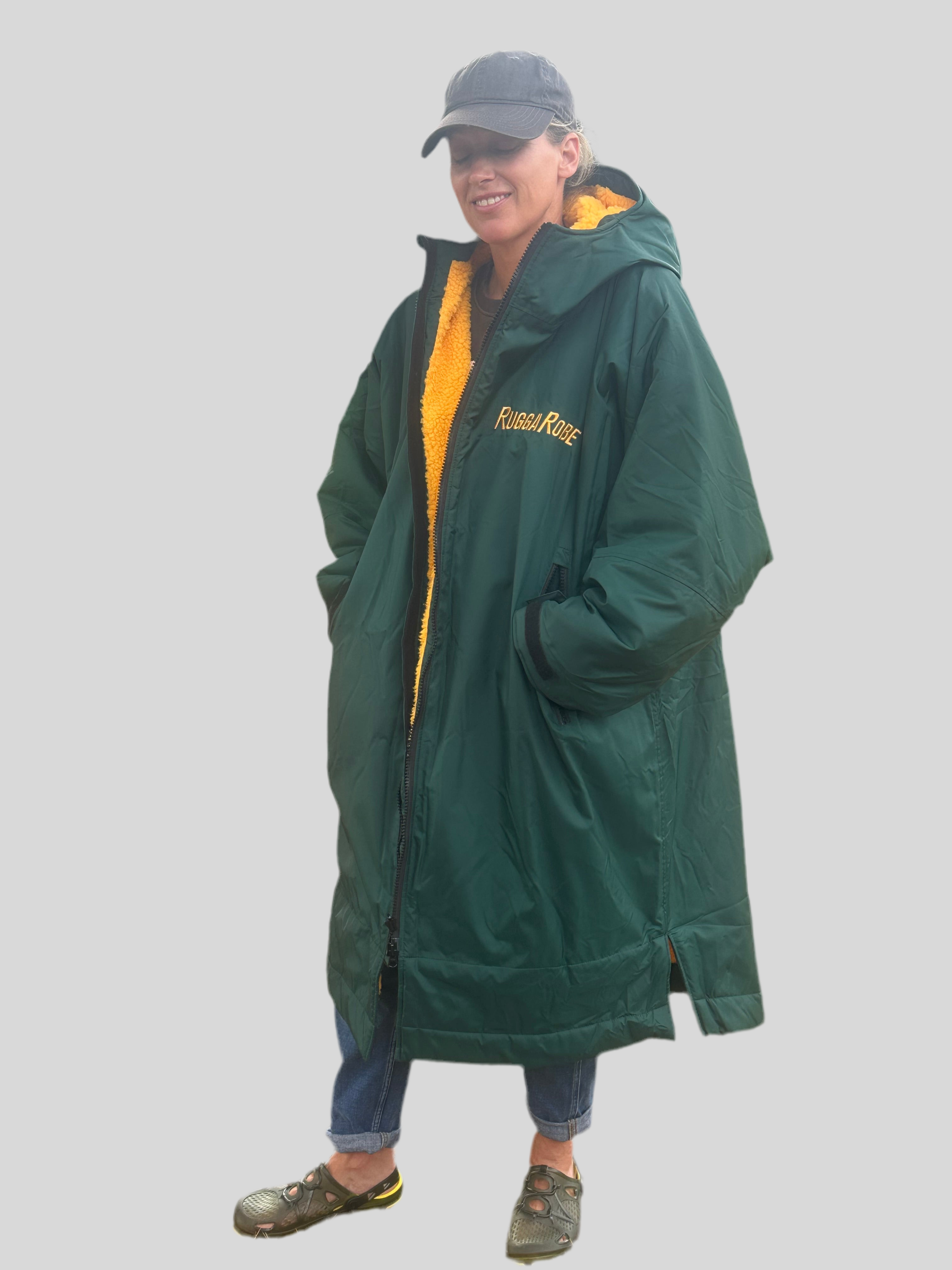 Lady wearing a green with gold fleece change robe on a grey background