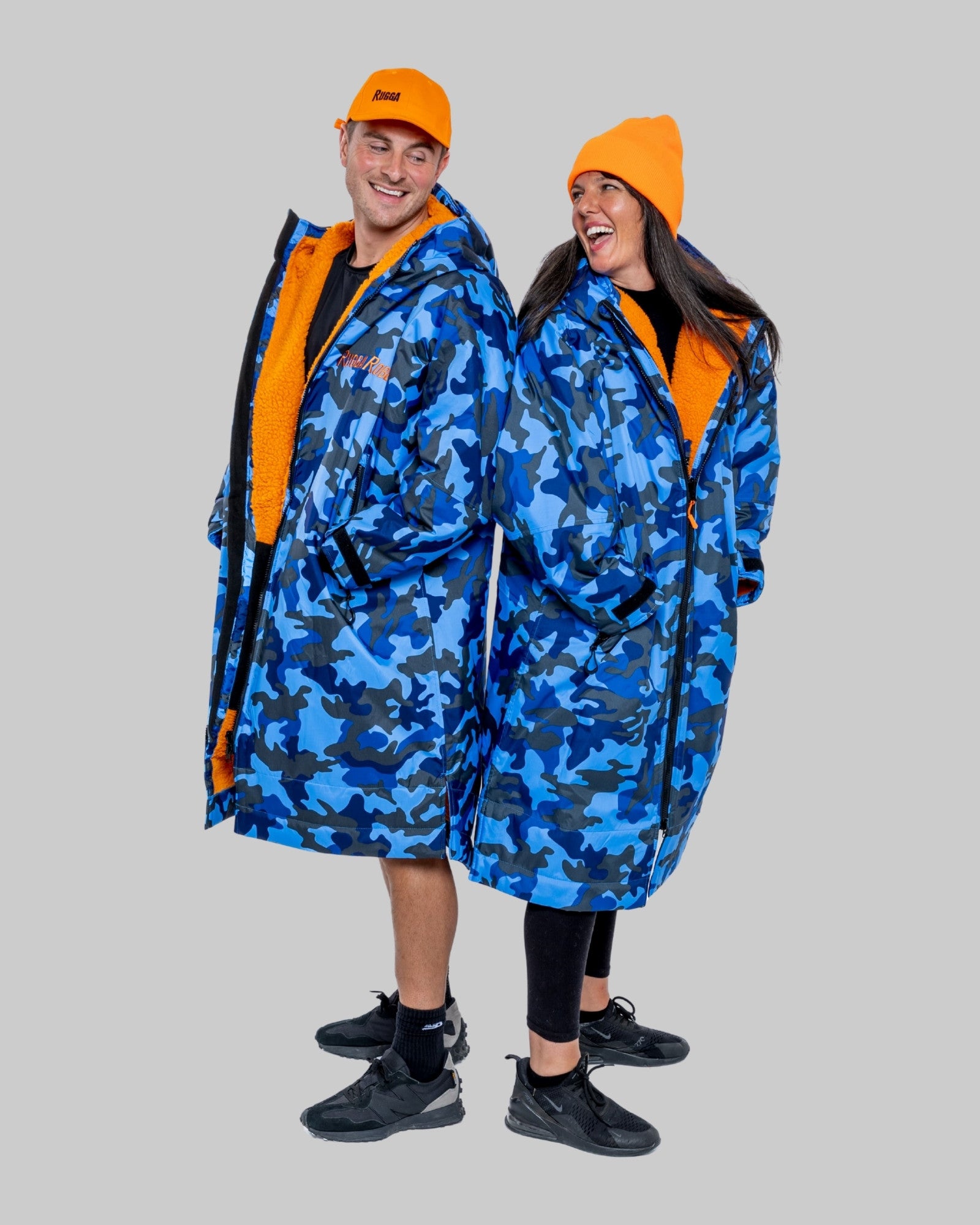 Two people wearing blue camouflage ruggarobes with orange accents on a grey background