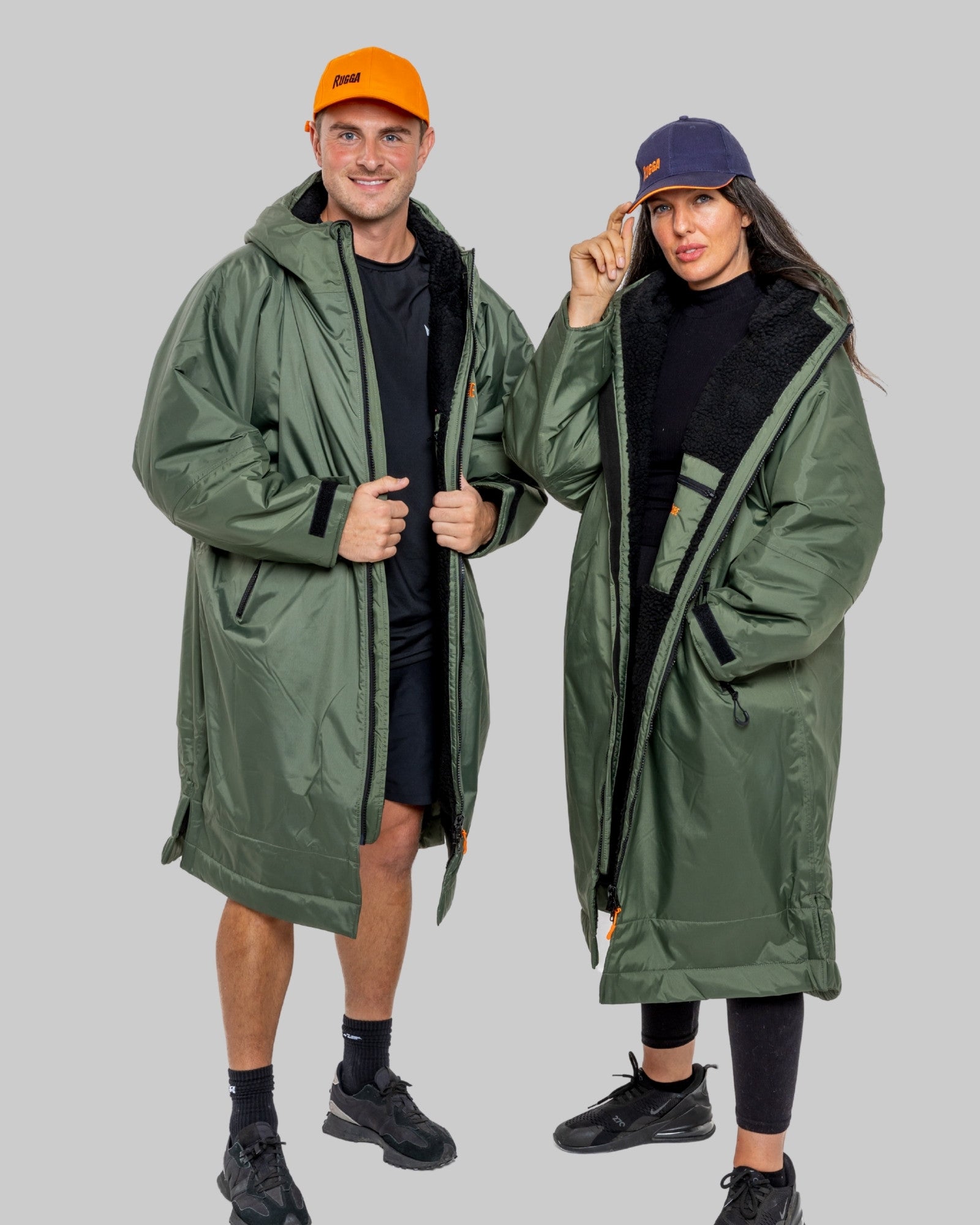 Two people wearing green ruggarobes on a grey background