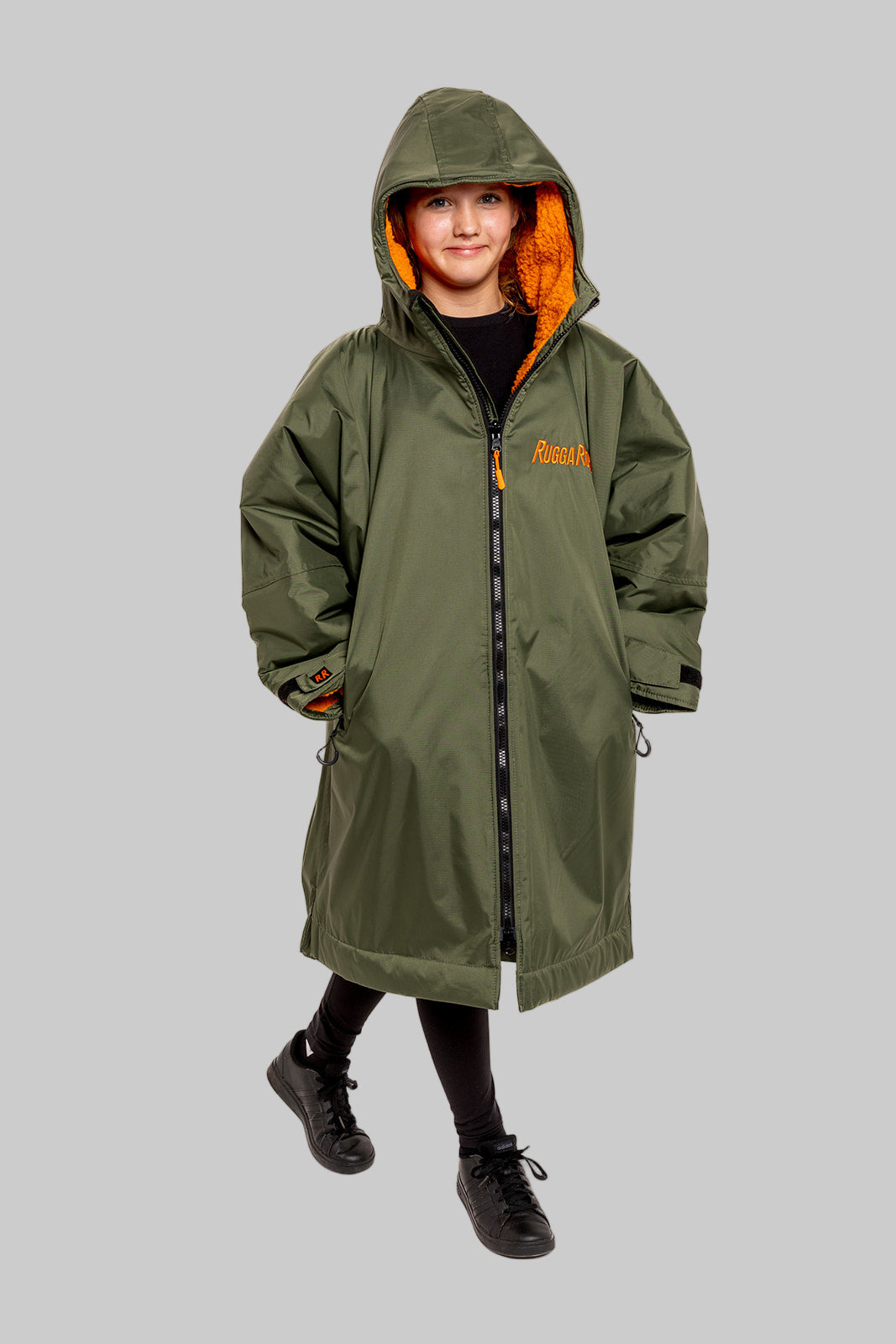 Model wearing RuggaRobe green change robe with orange fleece interior on grey background