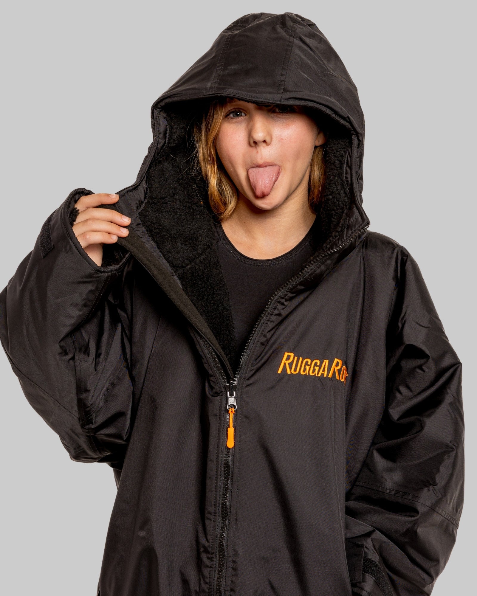 Child wearing RuggaRobe black change robe with black fleece interior on grey background