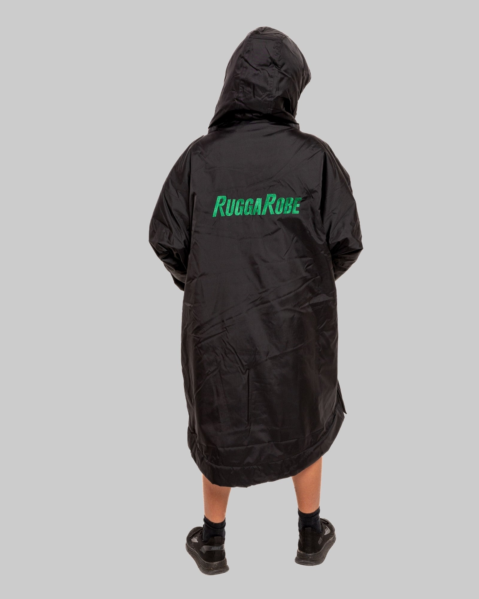 Person wearing a black change robe with 'Rugga Robe' branding on the back against a gray background