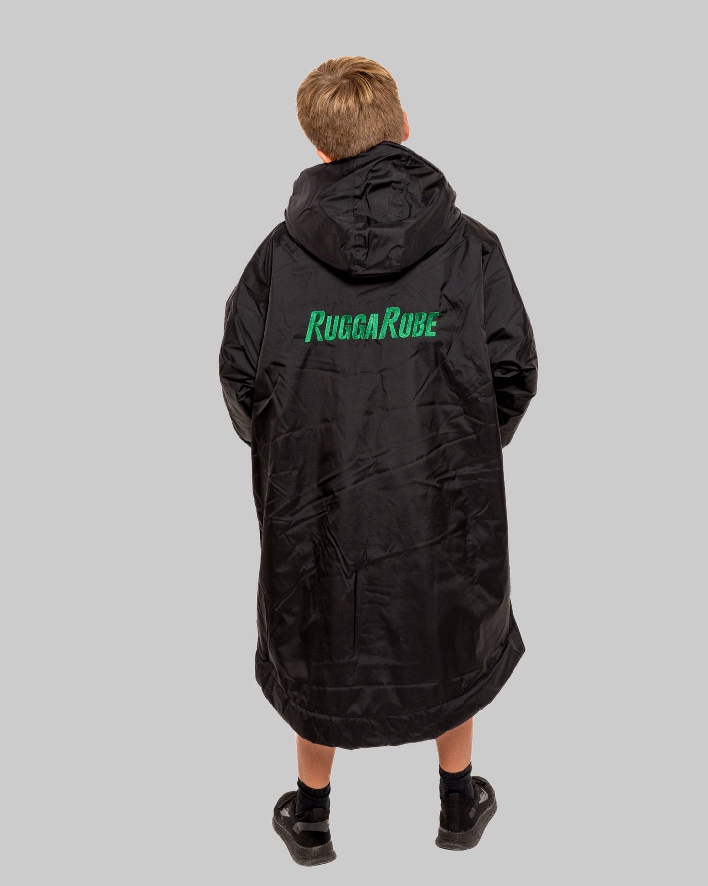 Model wearing RuggaRobe black change robe with green fleece interior on grey background