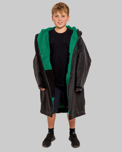Model wearing RuggaRobe black change robe with green fleece interior on grey background