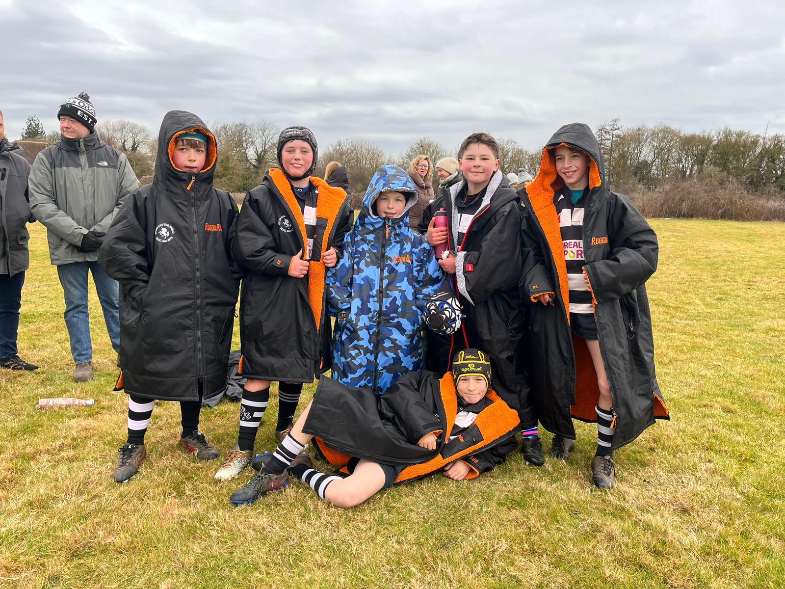 Group of children on a sports field wearing colourful RuggaRobe Change robes