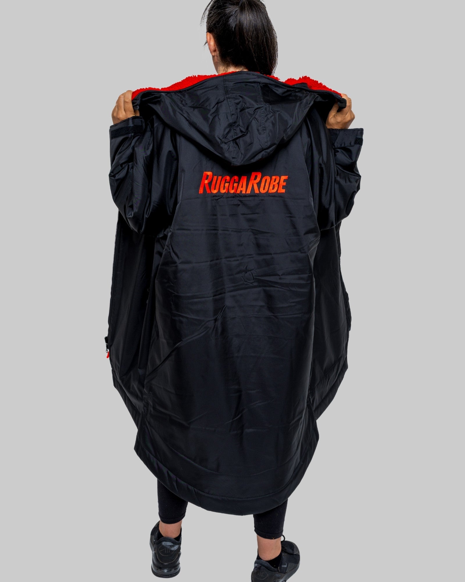 Person wearing a black 'Rugga Robe' robe with red text on a gray background
