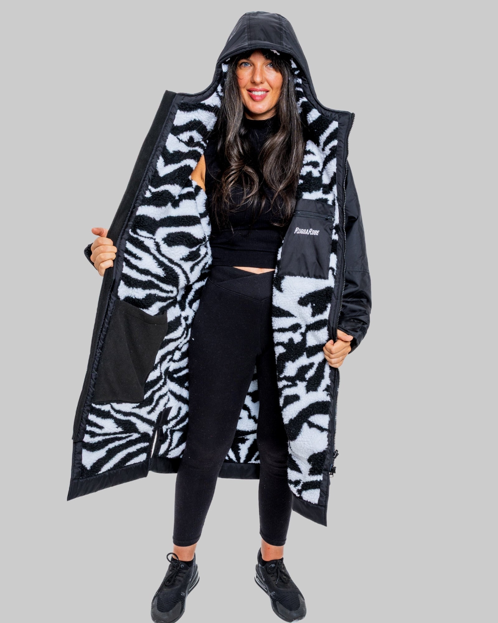 Person wearing a black and zebra patterned ruggarobe with  on a gray background