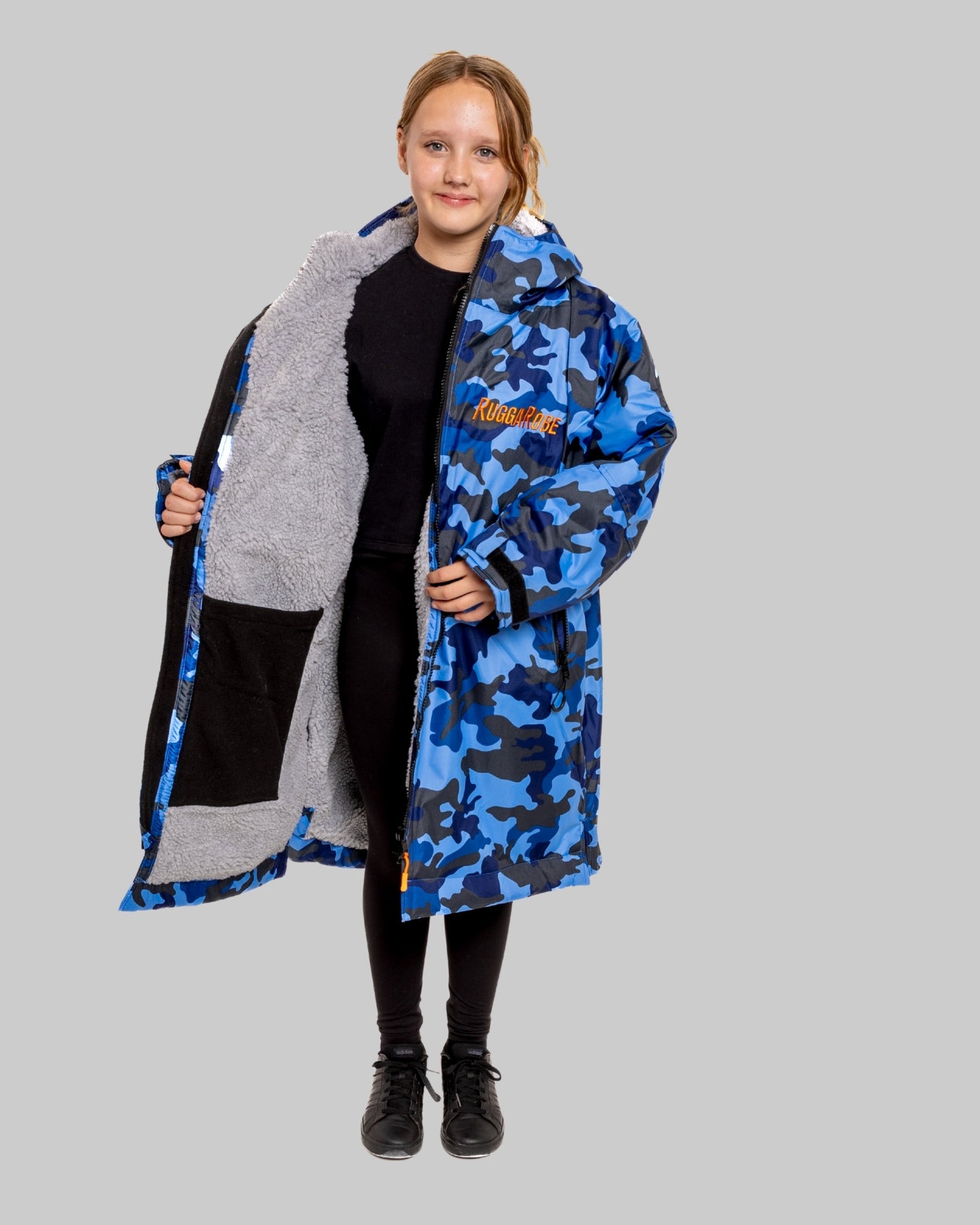 Model wearing RuggaRobe blue camo change robe with grey fleece interior on grey background