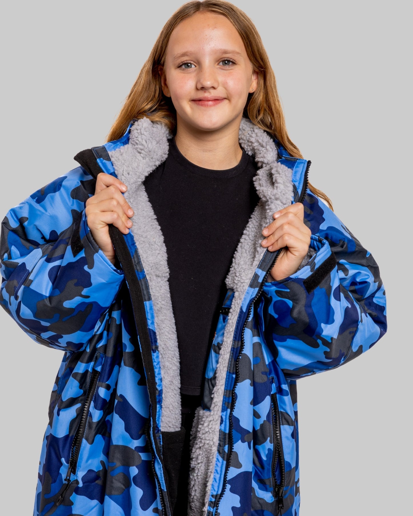 Model wearing RuggaRobe blue camo change robe with grey fleece interior on grey background
