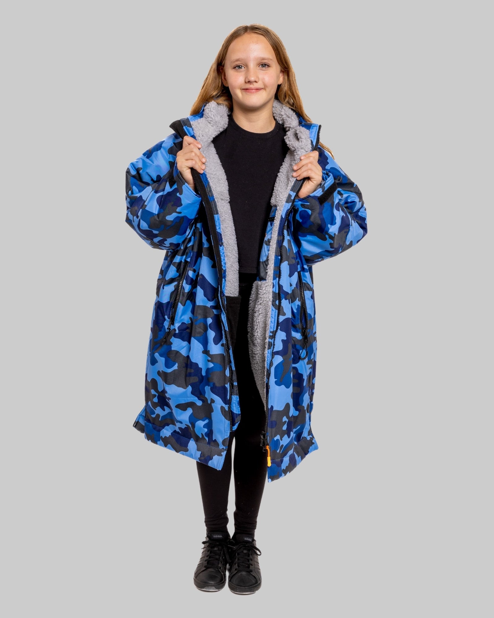 Model wearing RuggaRobe blue camo change robe with grey fleece interior on grey background