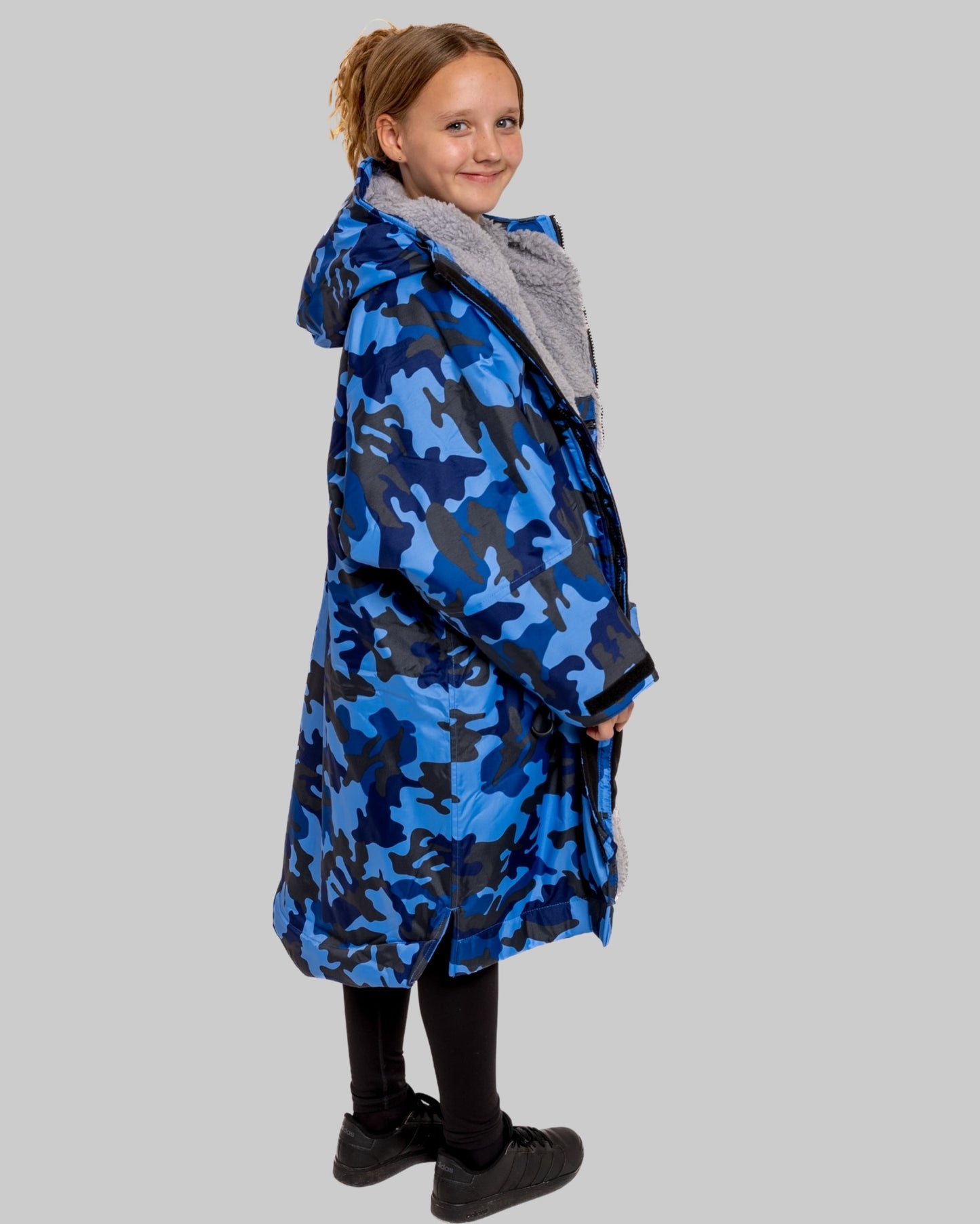 Model wearing RuggaRobe blue camo change robe with grey fleece interior on grey background