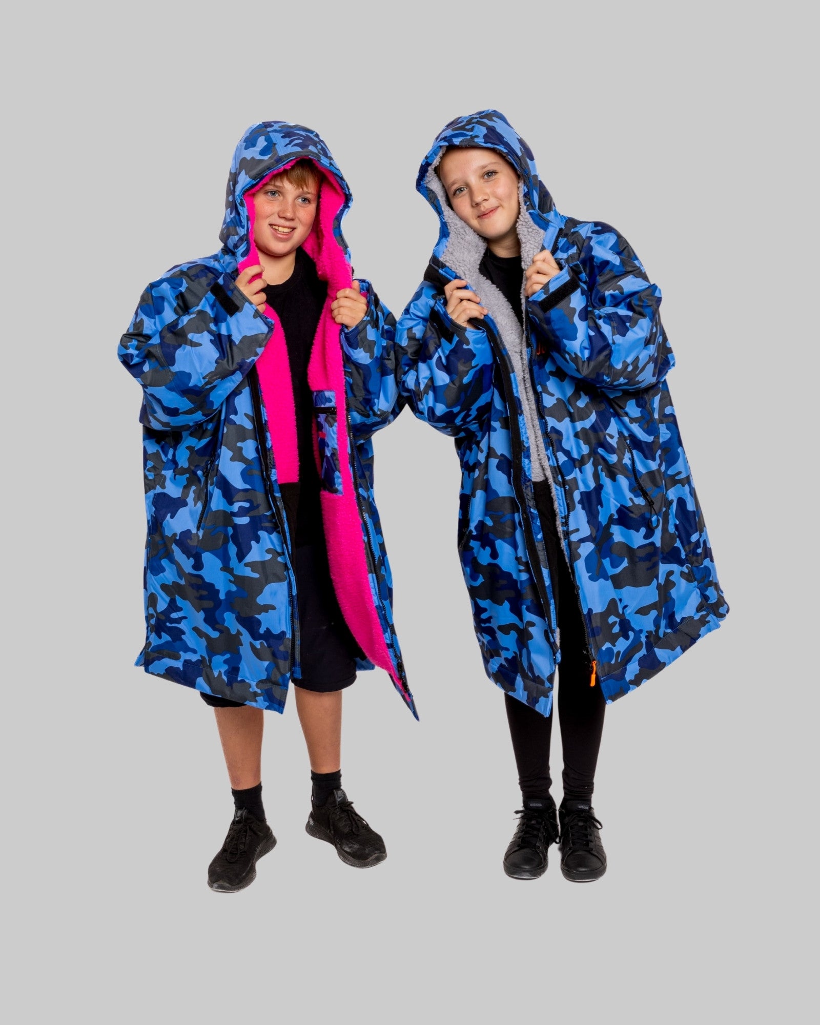 Two childre wearing RuggaRobe blue camo change robe on grey background