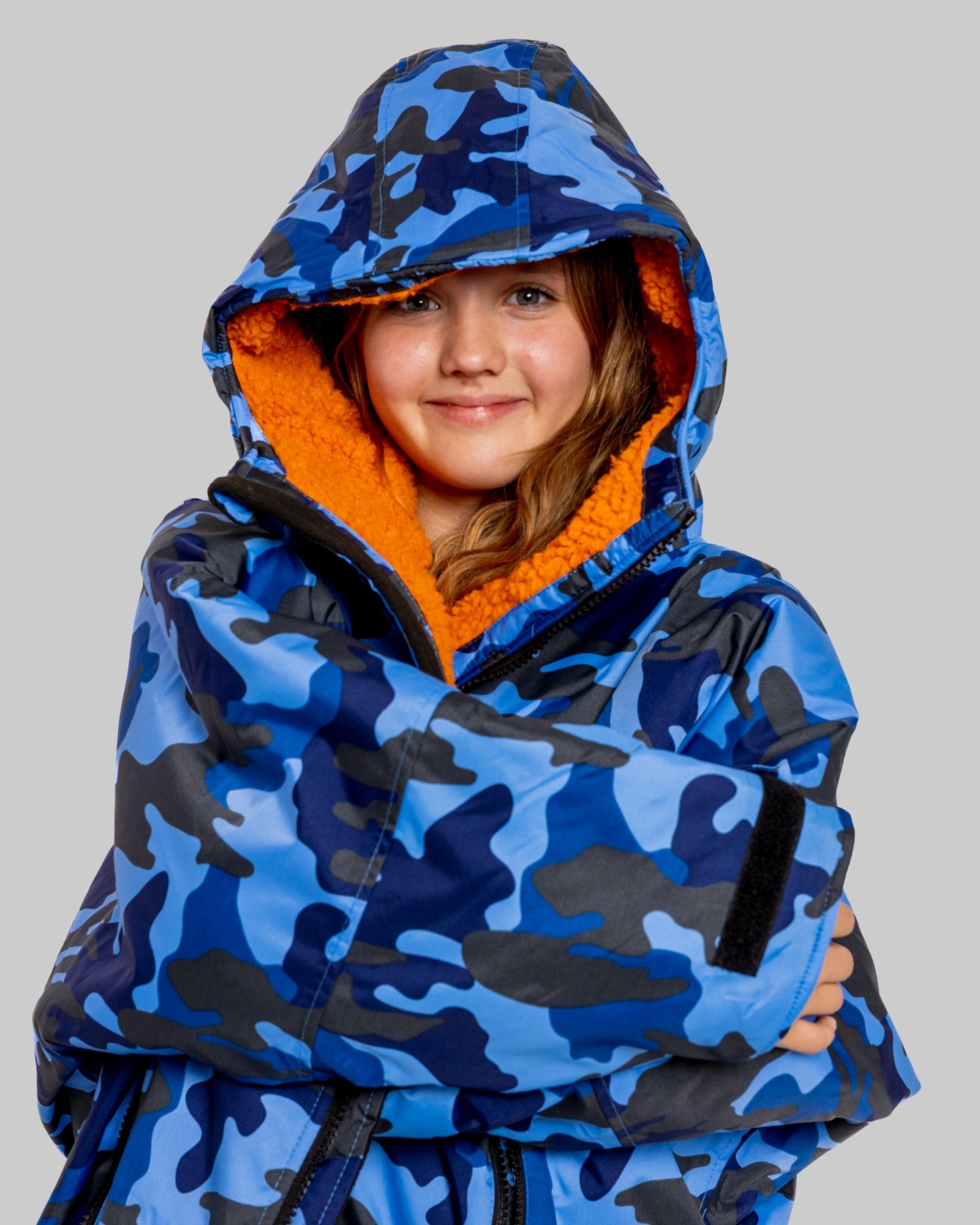 Model wearing RuggaRobe blue camo change robe with orange fleece interior on grey background