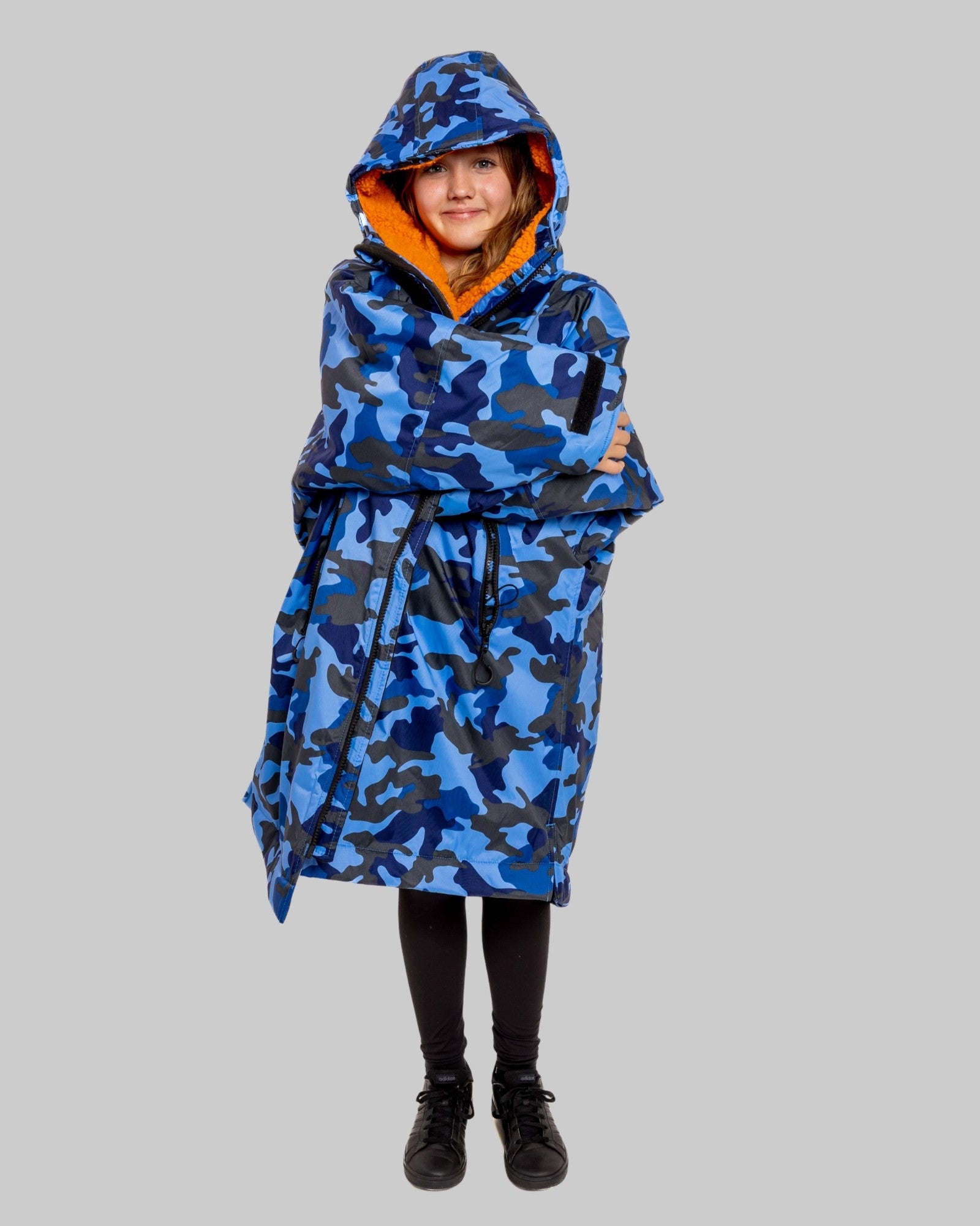 Model wearing RuggaRobe blue camo change robe with orange fleece interior on grey background