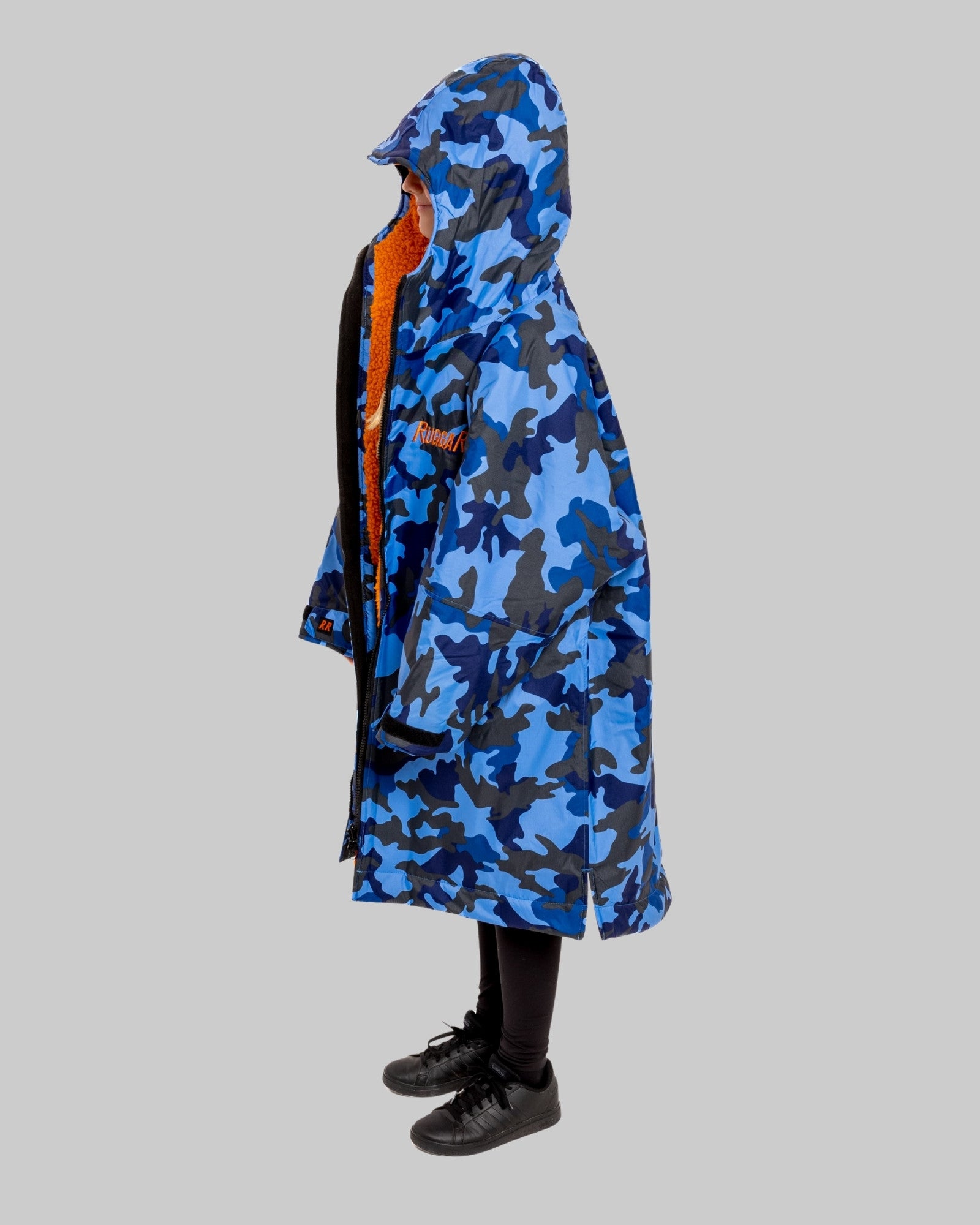 Model wearing RuggaRobe blue camo change robe with orange fleece interior on grey background