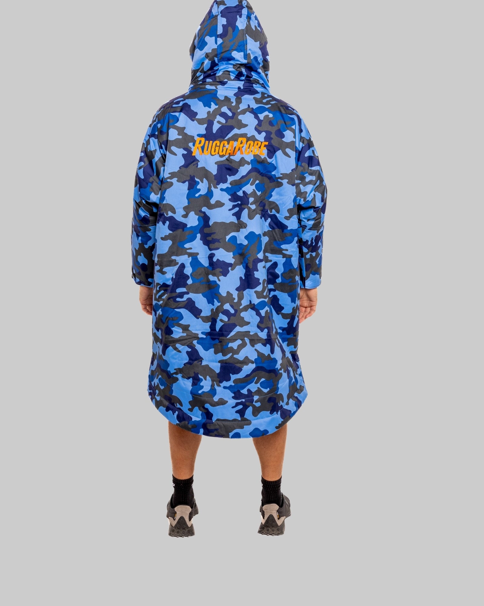 Person wearing a blue camouflage change robe with 'RuggaRobe' logo on a grey background